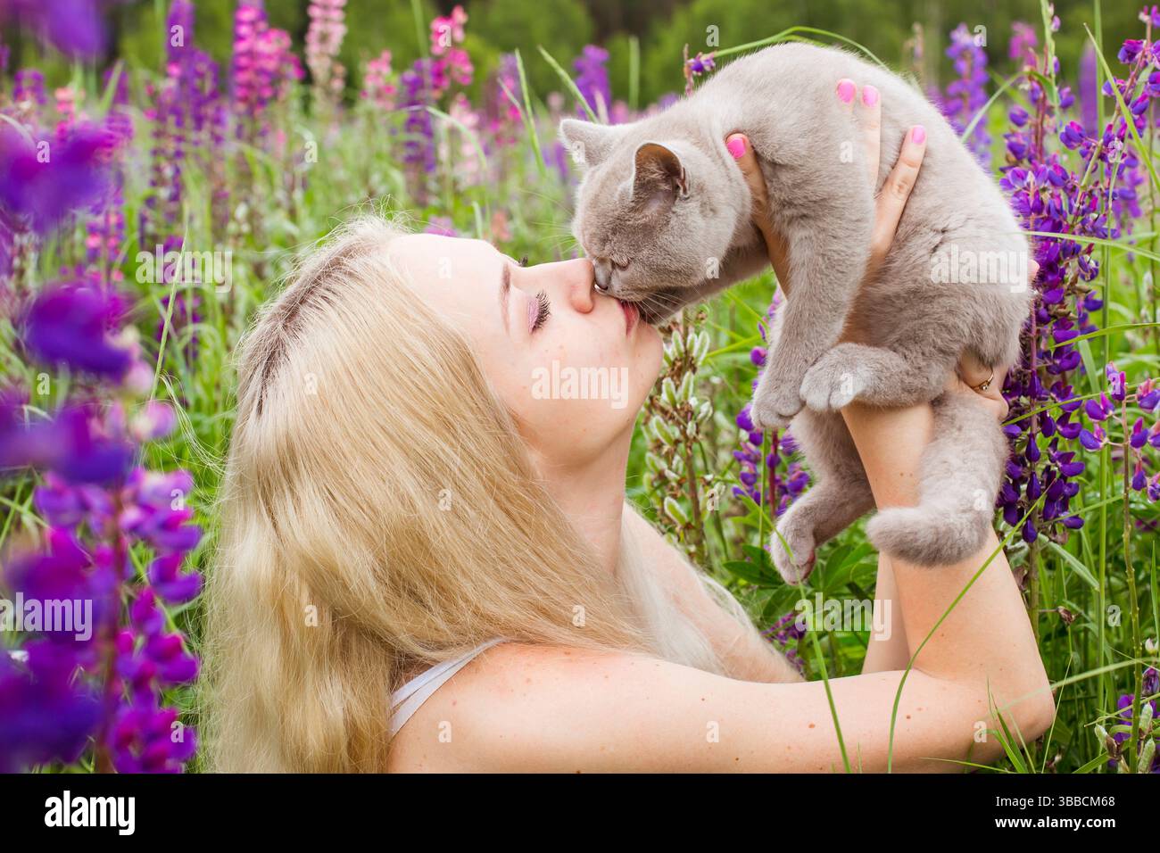 moscou, russie, 13.07.2017 Une femme tient un chat et l'embrasse. Le chat est gris et la femme est blonde. La scène est heureuse et affectueuse Banque D'Images