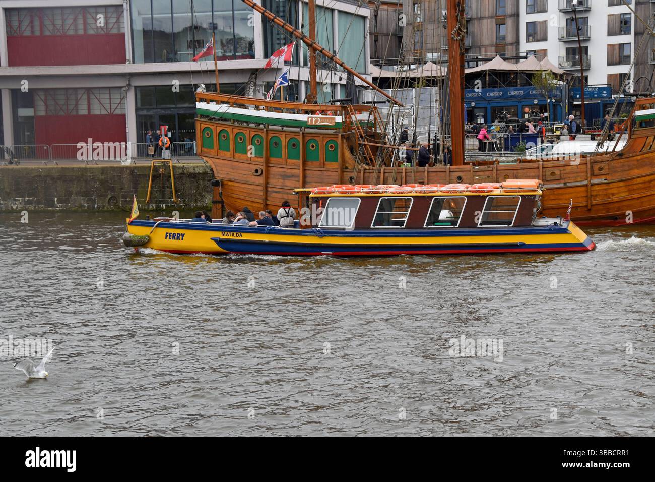 Bristol Harbour Ferry passe devant la réplique historique du navire The Matthew, dans le port flottant de Bristol, avril 2025 Banque D'Images