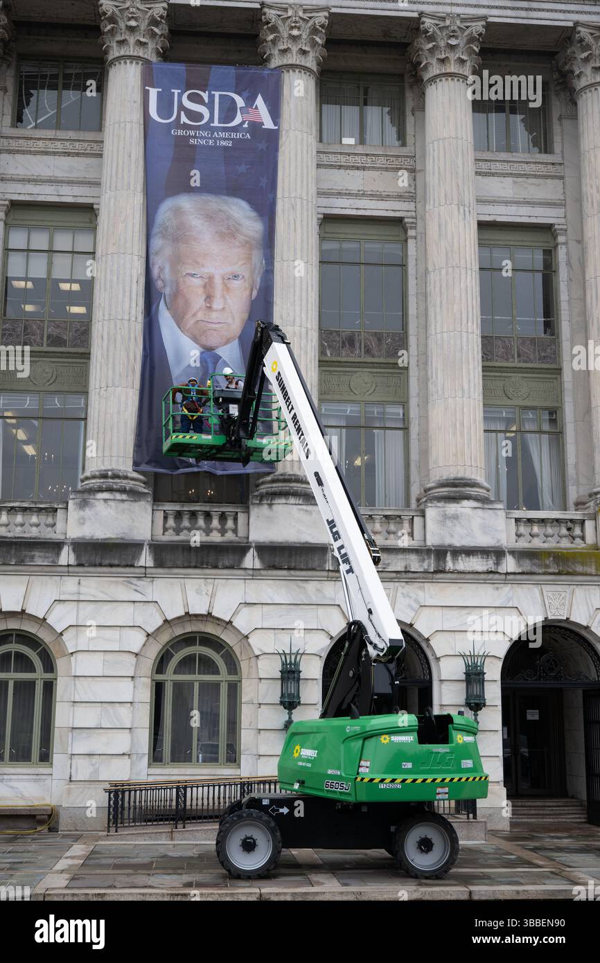 Washington, États-Unis. 14 mai 2025. Les travailleurs accrochent une énorme bannière d’un président américain en couvaison Donald Trump aux côtés d’une bannière du président Abraham Lincoln sur la façade du ministère de l’Agriculture, bâtiment du siège social Jamie L. Whitten, 14 mai 2025 à Washington, DC les bannières marquent le 163e anniversaire de l’agence avec ce qui est décrit comme une « esthétique nord-coréenne ». Crédit : Christophe Paul/USDA photo/Alamy Live News Banque D'Images