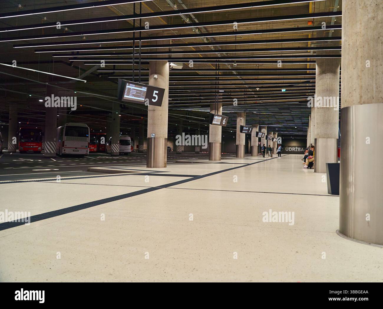 Une station de bus vide à l'intérieur avec des bus stationnés et de grandes colonnes Banque D'Images
