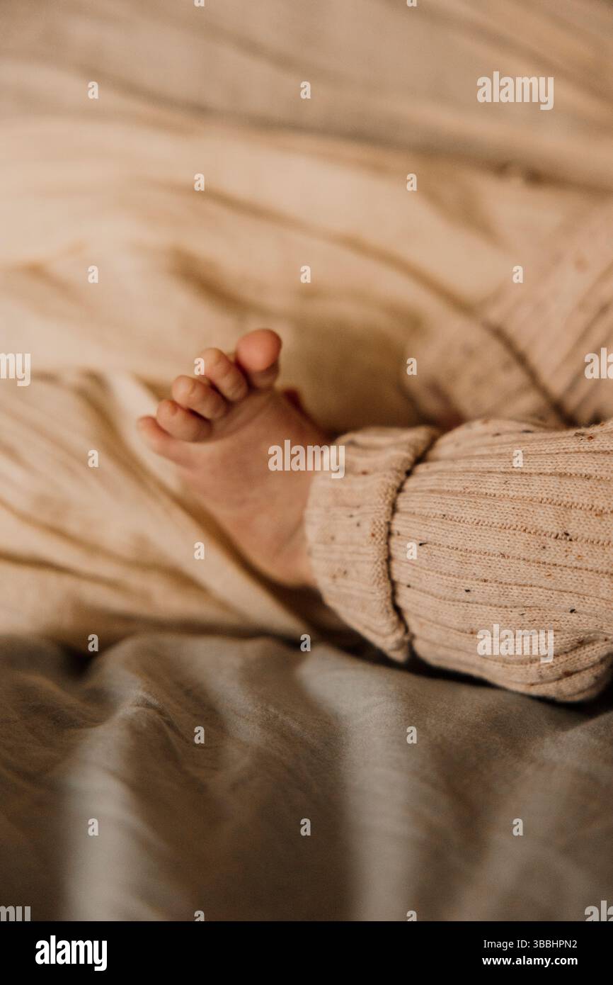 petits pieds de bébé dans une lumière chaude. Banque D'Images