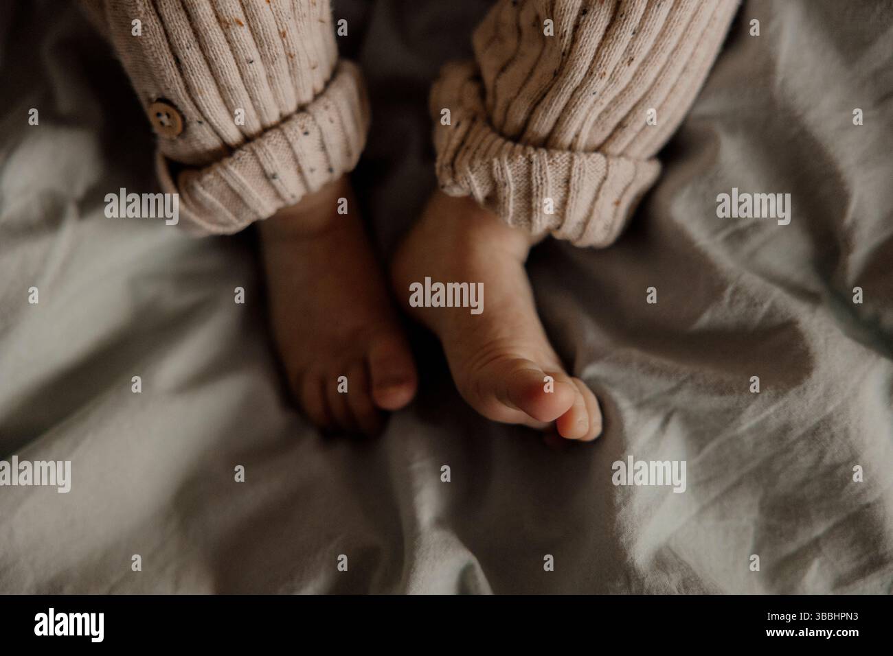 petits pieds de bébé dans une lumière chaude. Banque D'Images