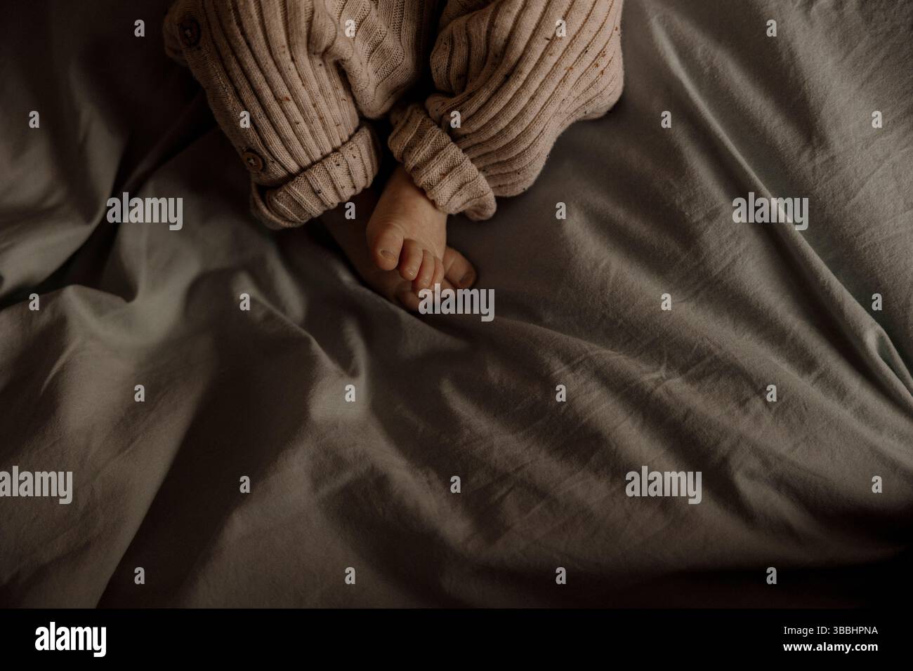 petits pieds de bébé dans une lumière chaude. Banque D'Images