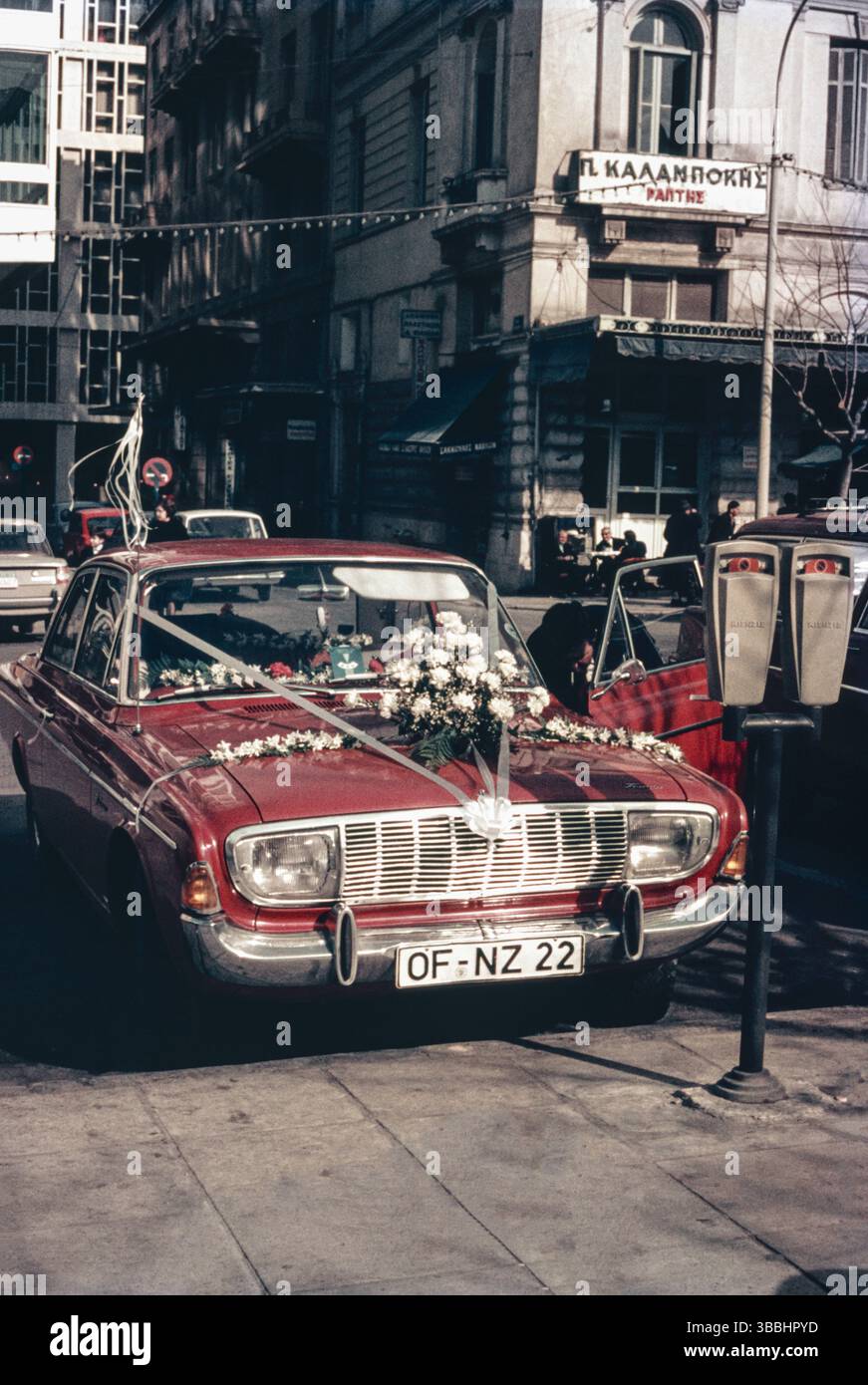 Voiture de mariage vintage ornée de fleurs dans une rue historique d'Europe de l'est. Célébration de mariage d'Europe de l'est capturée avec une voiture ancienne Banque D'Images