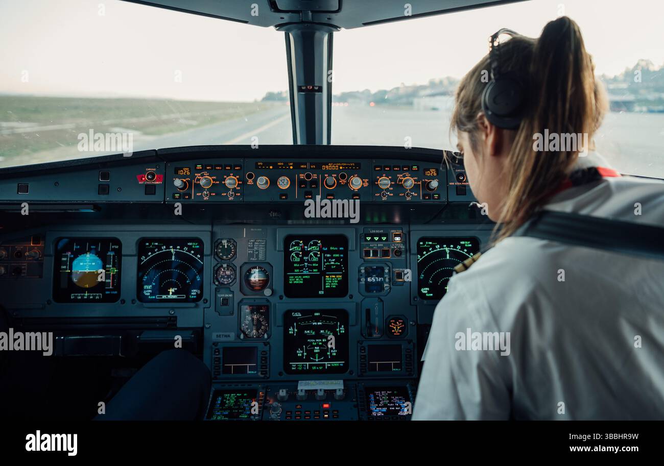 Copilote féminine dans le cockpit de l'avion pendant les procédures de pré-vol Banque D'Images