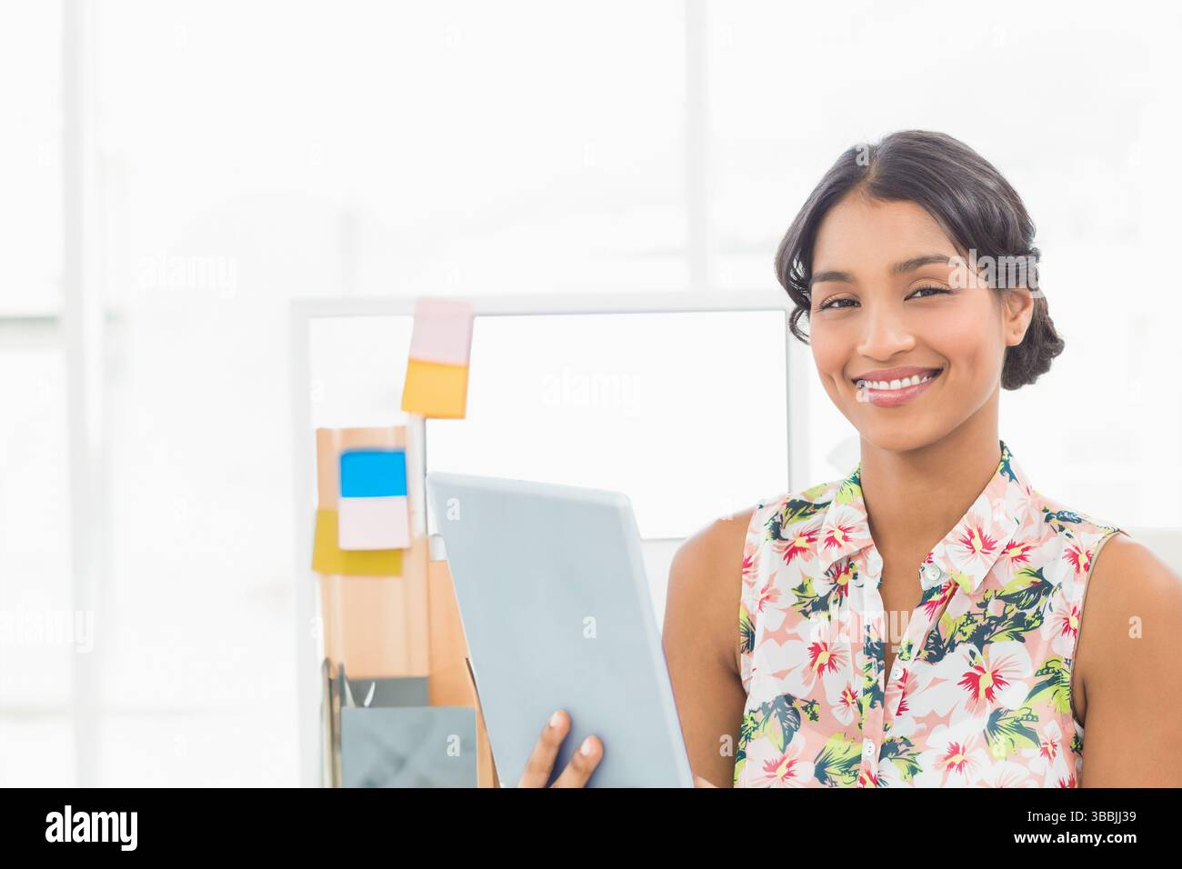 Tableau blanc affiche des notes adhésives colorées dans un bureau moderne, avec tablette sur le bureau Banque D'Images