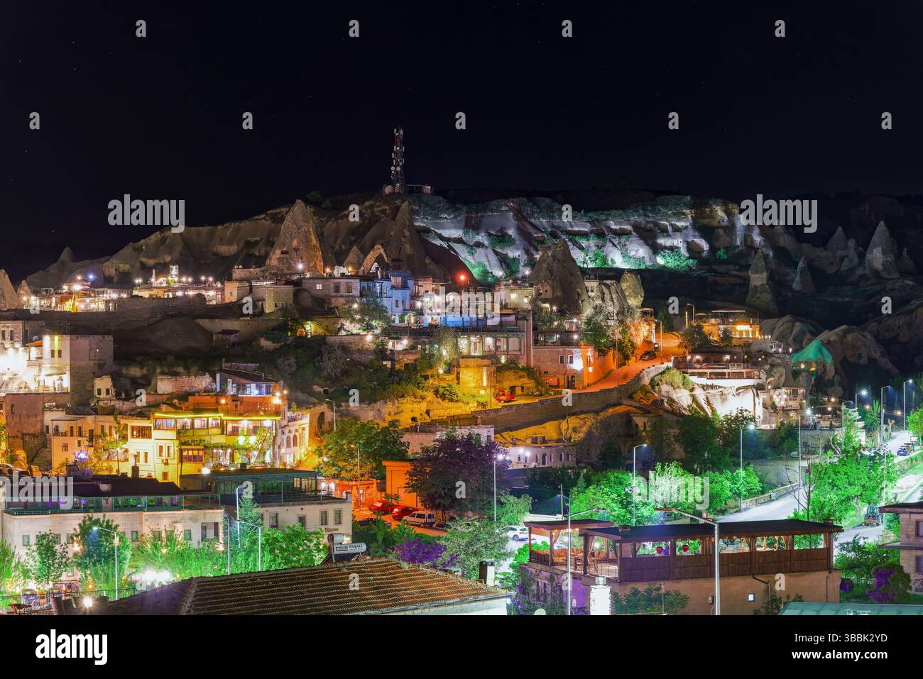 La vue nocturne de Goreme Cappadoce révèle des maisons illuminées et des formations rocheuses qui brillent sous le ciel sombre de la vallée. Banque D'Images