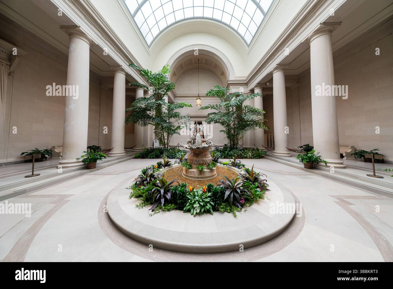 WASHINGTON DC — le West Garden court de la National Gallery of Art offre un espace de jardin intérieur tranquille dans le bâtiment néoclassique de l'Ouest conçu par l'architecte John Russell Pope. Cette élégante cour en marbre dispose d'une fontaine centrale entourée de plantes tropicales, reflétant la tradition des jardins de la Renaissance italienne. Avec une lumière naturelle abondante qui traverse les puits de lumière au-dessus, des bancs de marbre confortables et un aménagement paysager soigneusement organisé, le Garden court offre aux visiteurs du musée un cadre paisible pour contempler et se reposer entre regarder la vaste collection d'art de la galerie Banque D'Images