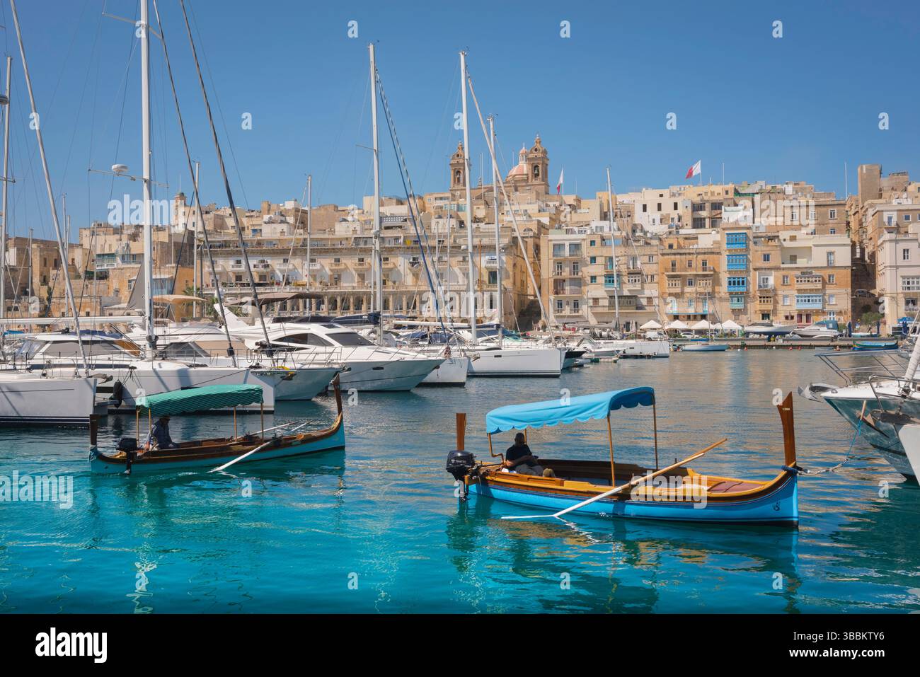 Port de Vittoriosa, vue de Vittoriosa vers la ville riveraine d'Isla montrant des ferries (dghajsa) et des yachts amarrés à Dockyard Creek, Malte Banque D'Images