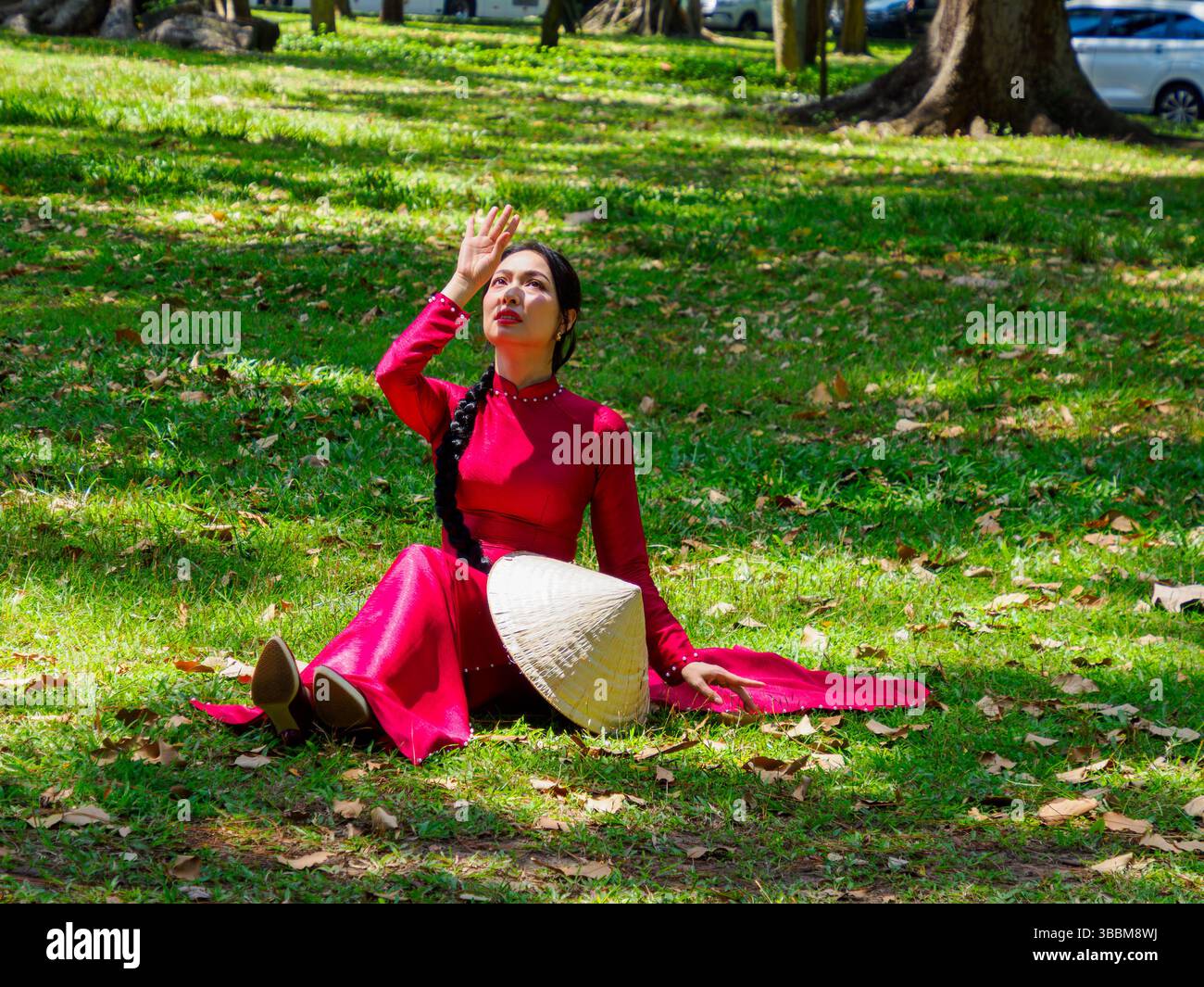 Femme vietnamienne pose en robe de style traditionnel, Independence place, Saigon, Vietnam. Banque D'Images