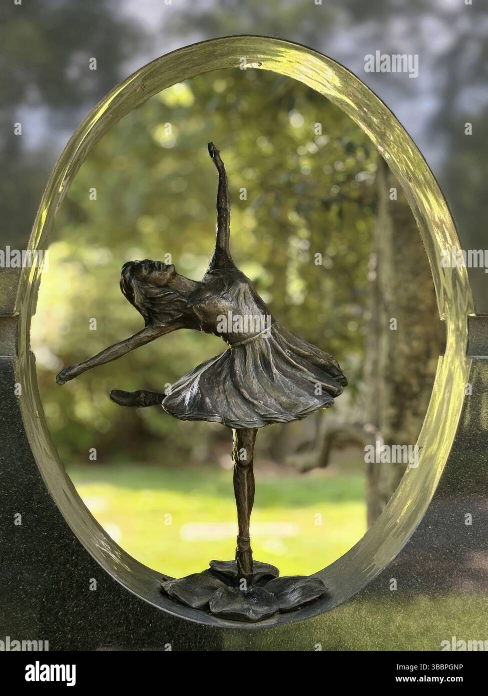 Une délicate ballerine en bronze en pleine danse, capturée dans un cadre circulaire Banque D'Images