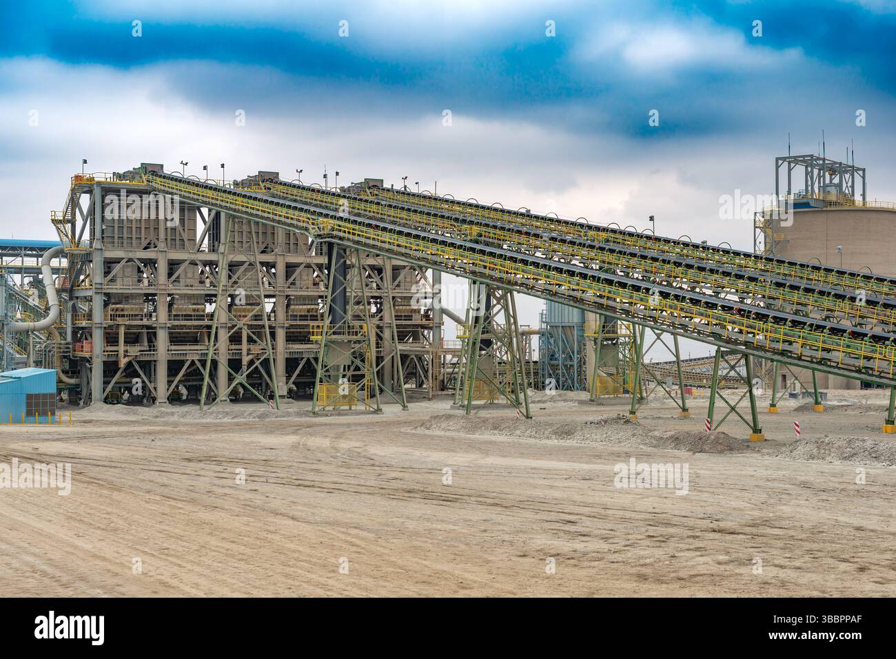 De vastes bandes transporteuses transportent régulièrement le minerai de cuivre vers l'installation de concassage dans une usine de traitement située dans une mine située au Chili. Banque D'Images