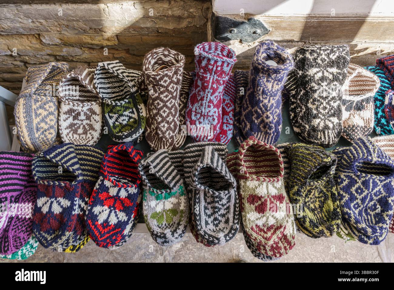 Une exposition colorée de pantoufles en laine faites à la main remplit un étal de marché à Khiva, en Ouzbékistan, mettant en valeur l'artisanat et les motifs textiles locaux. Banque D'Images