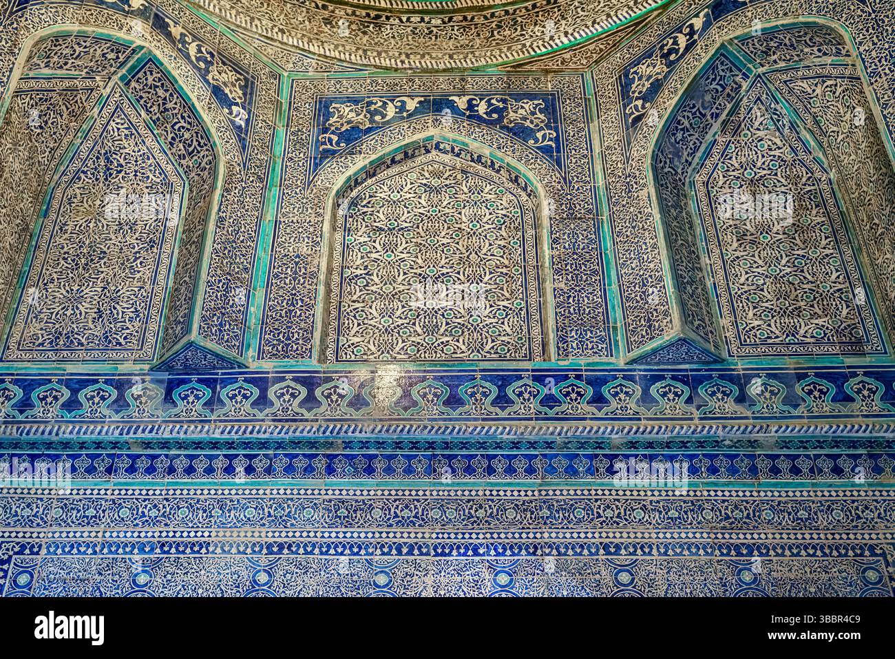 Des carreaux émaillés bleus et verts aux motifs floraux et géométriques complexes recouvrent le mur intérieur du mausolée Pakhlavan Mahmoud à Khiva Ouzbékistan. Banque D'Images
