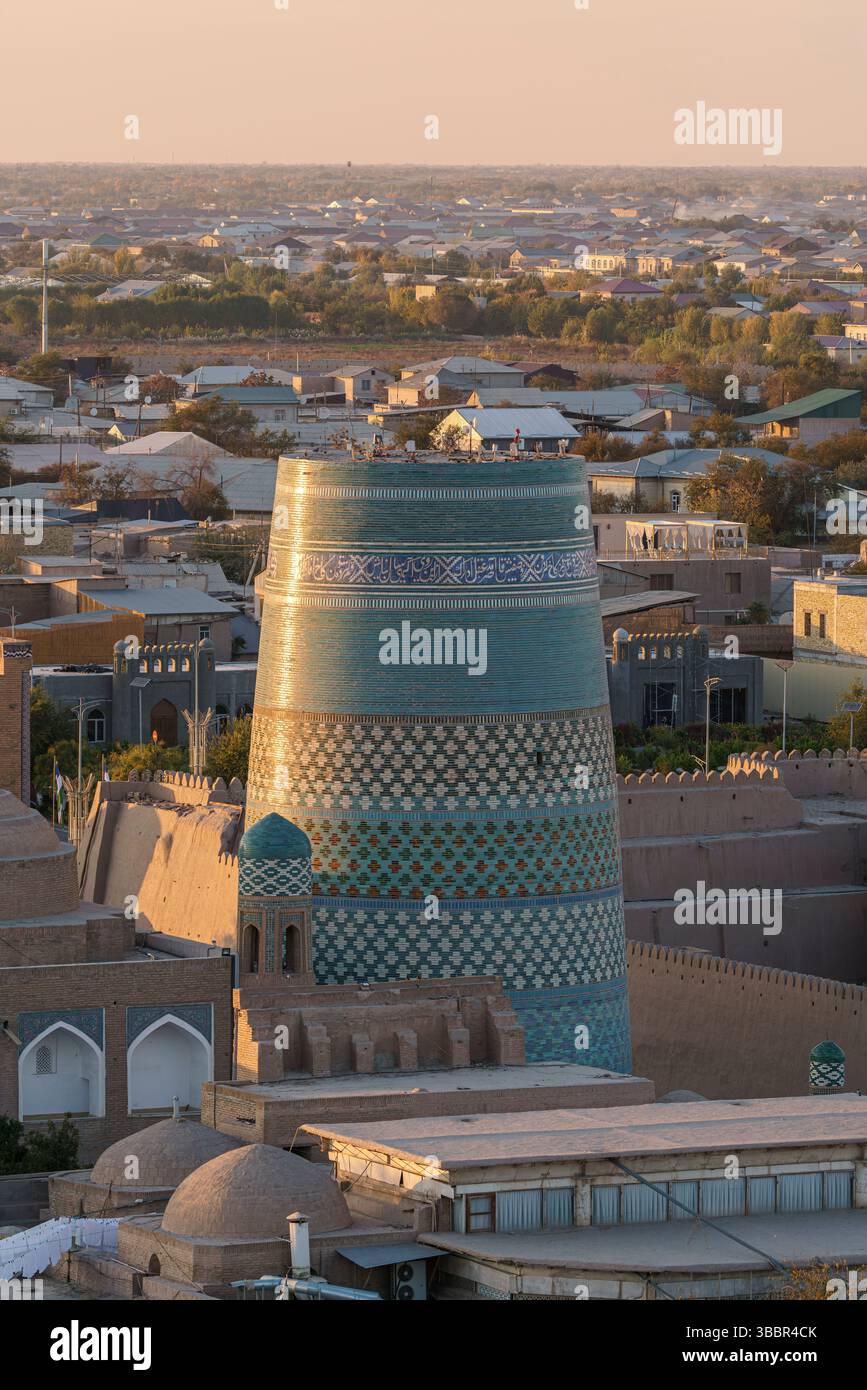 Le minaret turquoise Kalta Minor aux motifs géométriques audacieux s’élève au-dessus des toits de Khiva Ouzbékistan à la lumière du soleil du soir. Banque D'Images