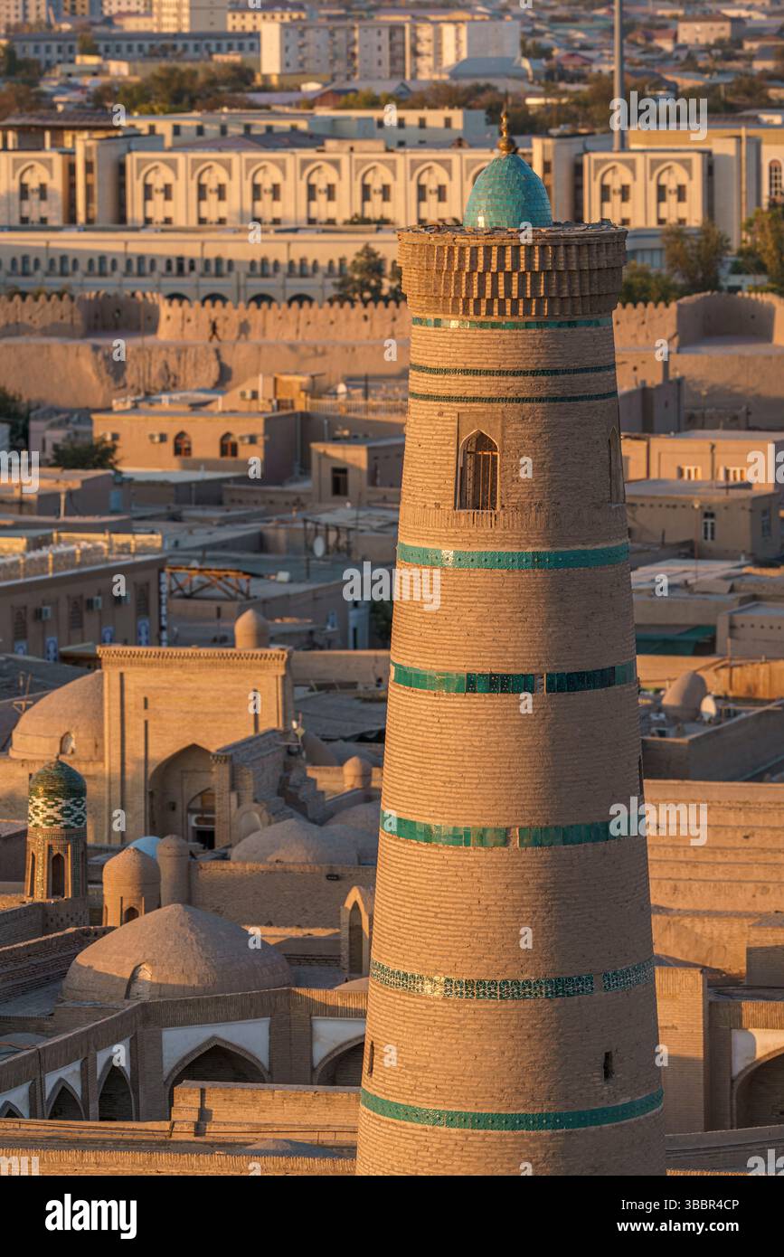 Juma Minaret s'élève au-dessus des toits et des rues sablonneuses de Khiva Ouzbékistan alors que le soleil doré se couche sur la vieille ville historique. Banque D'Images