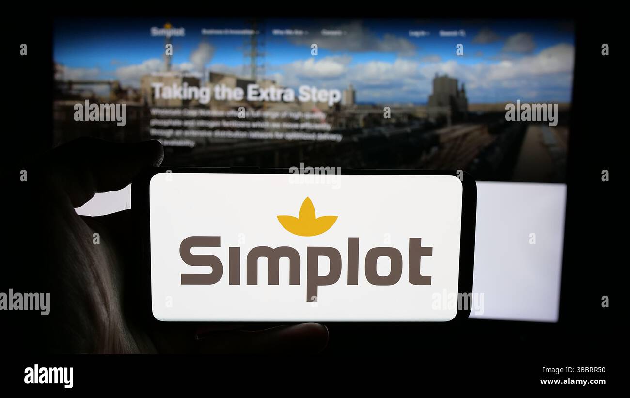 Allemagne. 26 avril 2025. Dans cette illustration de photo, une personne tient un téléphone portable avec le logo de US Agri business J. R. Simplot Company sur l'écran devant la page Web. (Crédit image : © timon Schneider/SOPA images via ZUMA Press Wire) USAGE ÉDITORIAL SEULEMENT ! Non destiné à UN USAGE commercial ! Banque D'Images