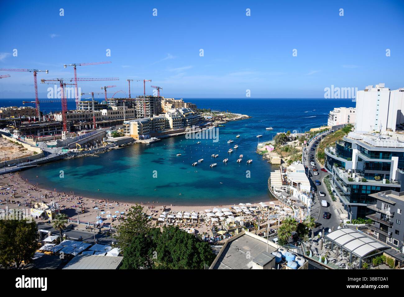 Vue aérienne de St George's Bay avec la plage d'eau turquoise avec des bateaux amarrés par une belle journée ensoleillée, St Julian's, Malte. Banque D'Images