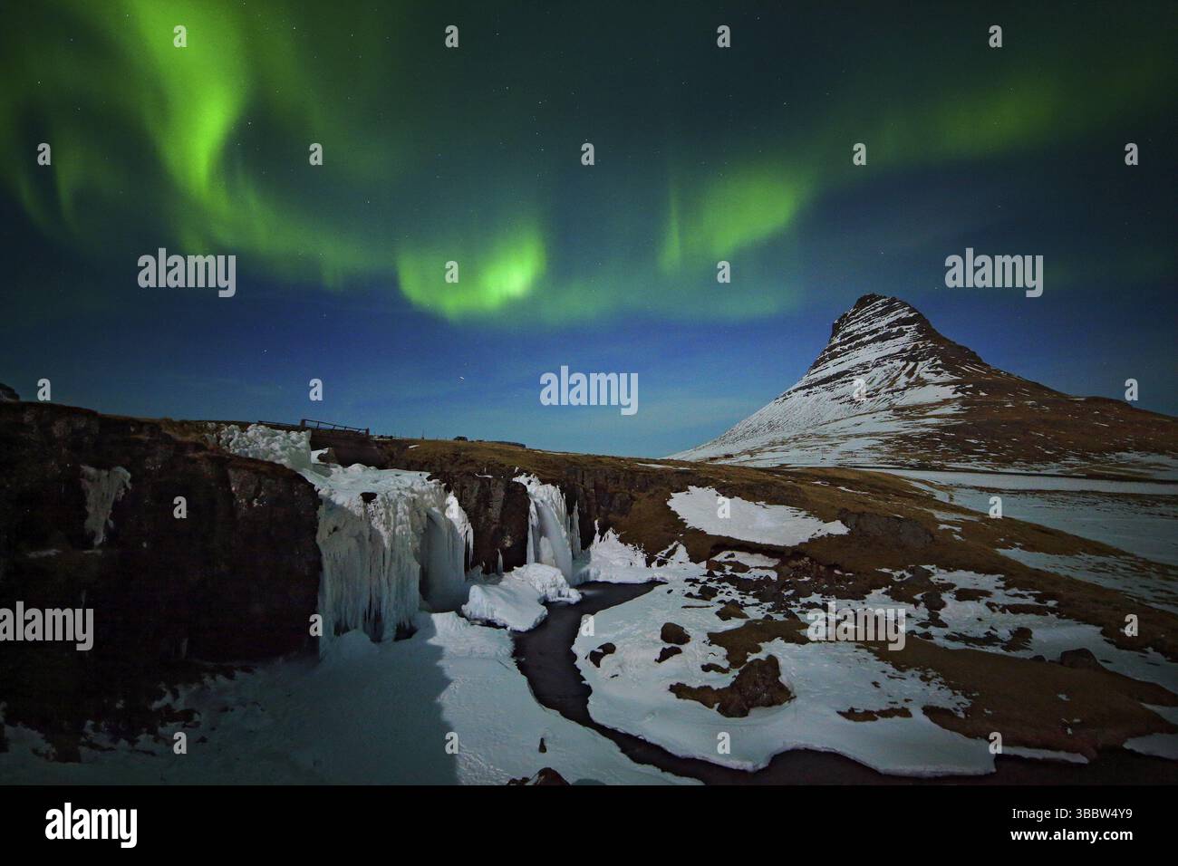 Aurora Borealis d'Islande. Belles aurores boréales vertes sur le ciel nocturne bleu foncé avec pic de neige, Kirkjufell, Islande, Europe Banque D'Images Aurora Borealis d'Islande. Belles aurores boréales vertes sur le ciel nocturne bleu foncé avec pic de neige, Kirkjufell, Islande, Europe Banque D'Images