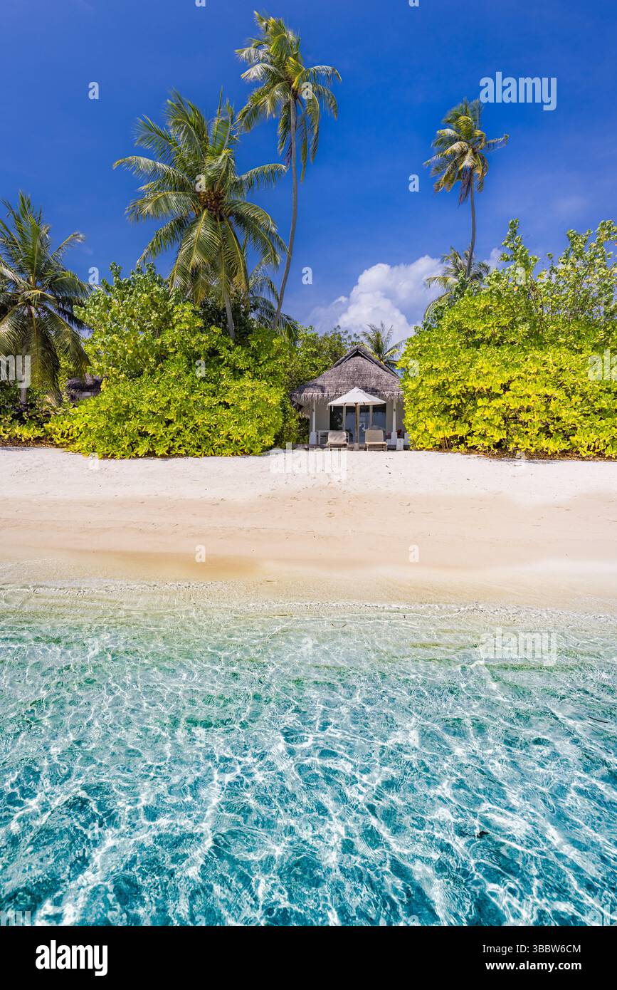Superbe station balnéaire tropicale avec chaises et parasol sous les palmiers, papier peint vertical de la côte pittoresque destination vacances d'été vue sur le paradis Banque D'Images