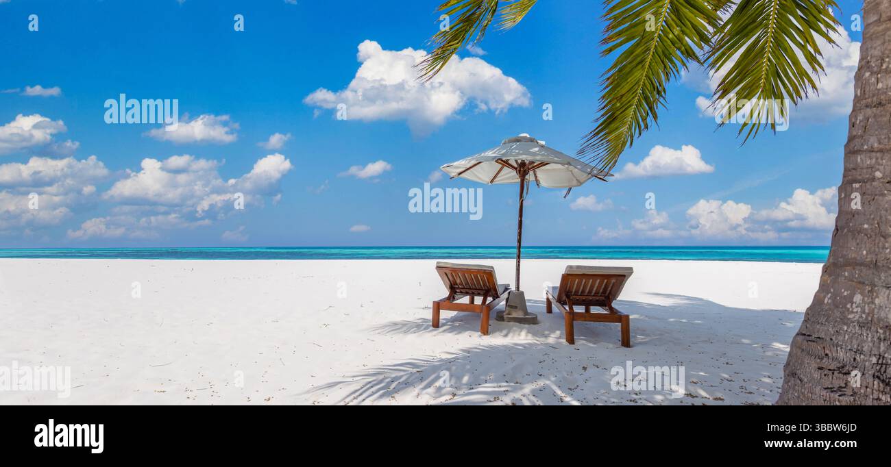 Belle plage panoramique avec des chaises ensoleillées sous parasol, couple romantique sur la destination de vacances île tropicale lune de miel, paysage d'été serein Banque D'Images