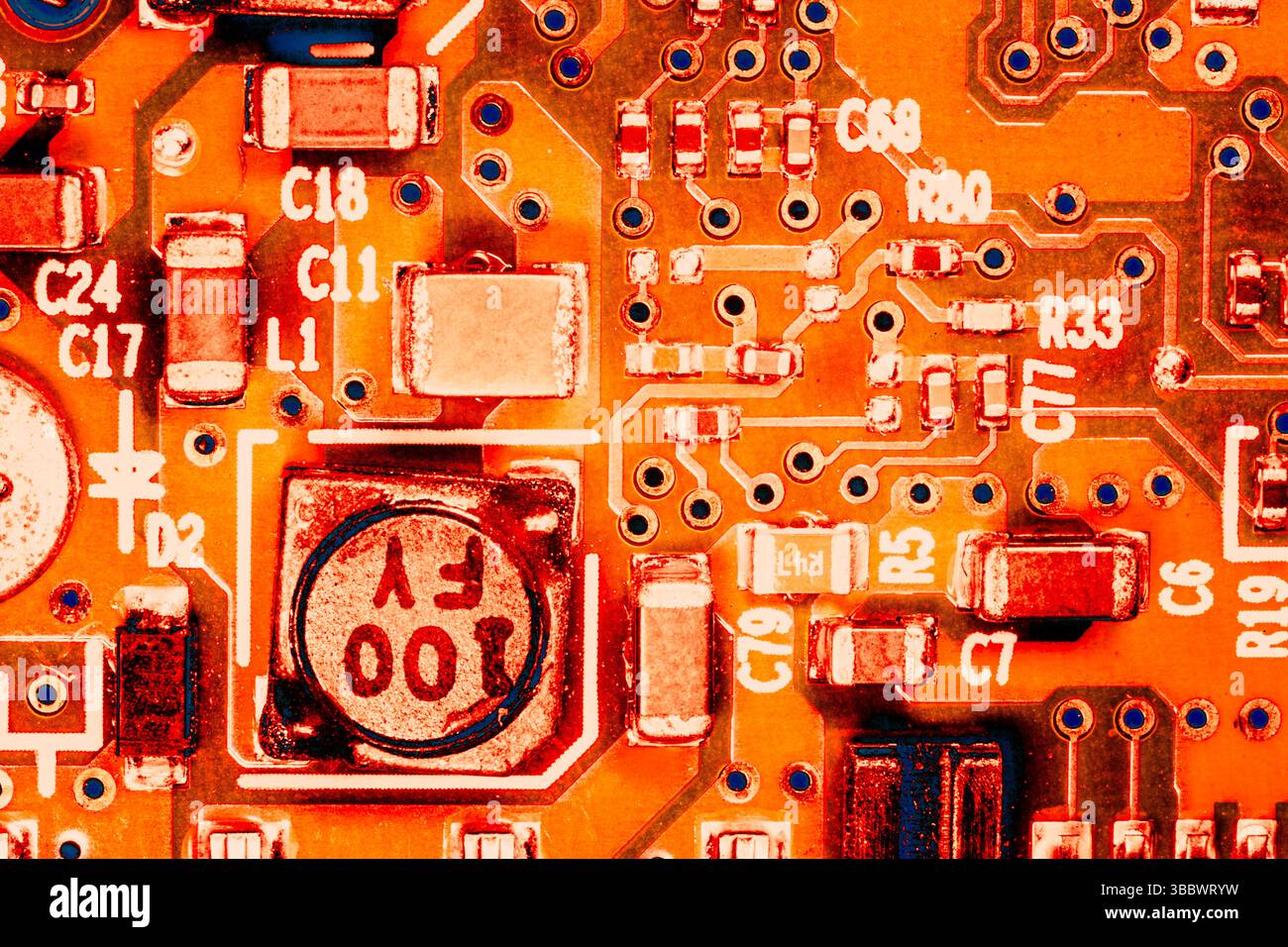 toile de fond abstraite de l'ingénierie matérielle : gros plan photo d'un circuit intégré coloré en orange Banque D'Images
