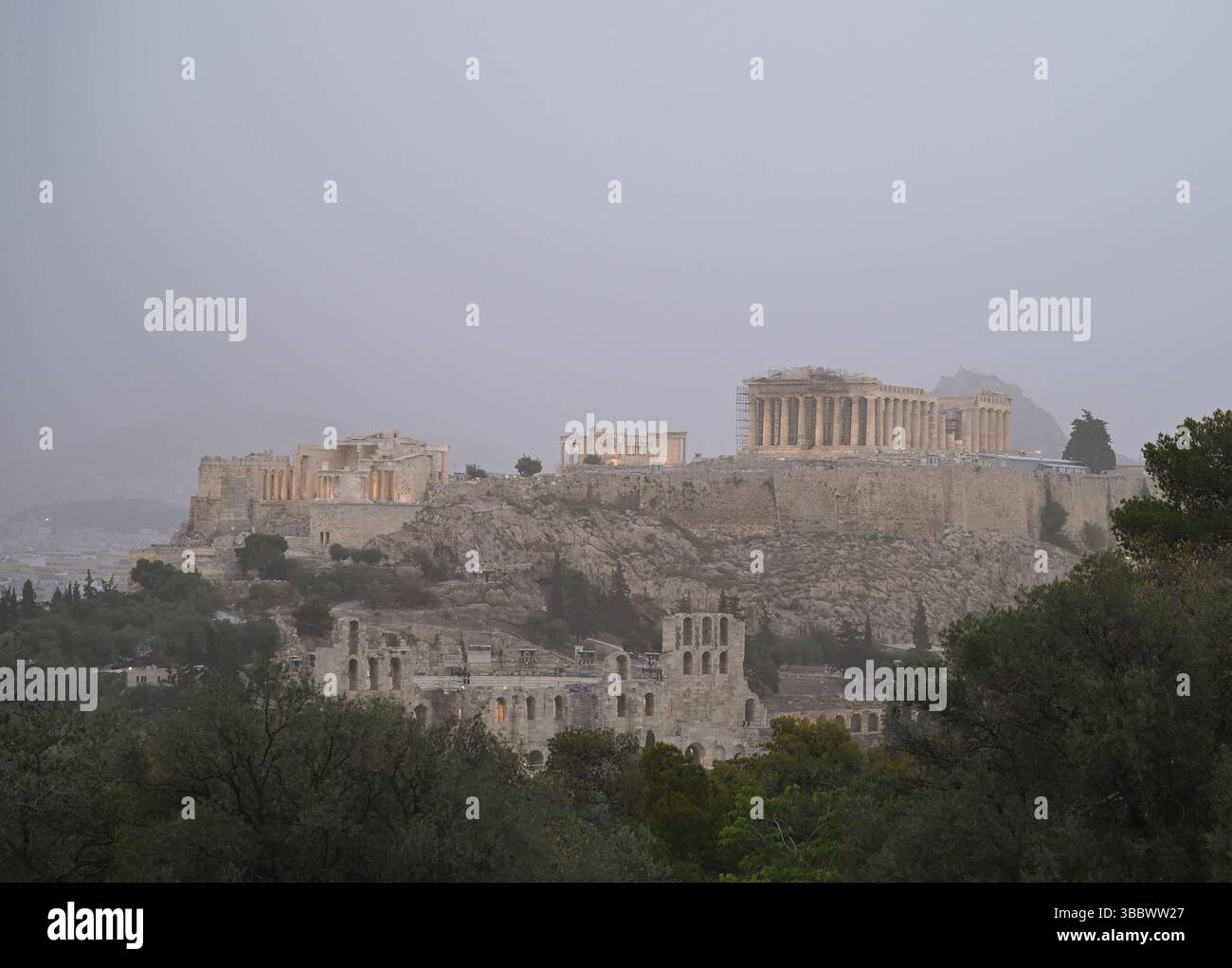 Athènes, Grèce, 16 mai 2025. L'ancienne Acropole est entourée de brume tandis qu'Athènes est couverte de nuages de poussière. Une épaisse couverture de poussière saharienne a balayé la capitale grecque vendredi, jetant de la brume sur la ville et suscitant des avertissements sanitaires de la part des autorités. Crédit : Dimitris Aspiotis/Alamy Banque D'Images