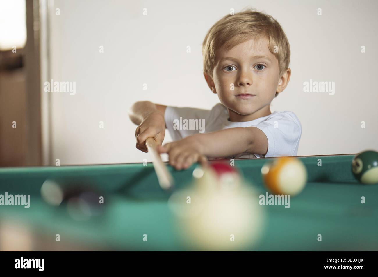 garçon de 5-6 ans jouant au billard Banque D'Images