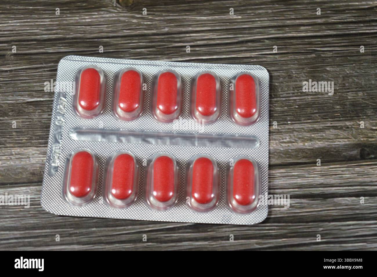 Comprimés de médicaments, comprimés rouges, traitement, remède, consommation de drogues, abus, concept de prescription, analgésiques et antibiotiques, analgésiques, prise d'un médicament Banque D'Images