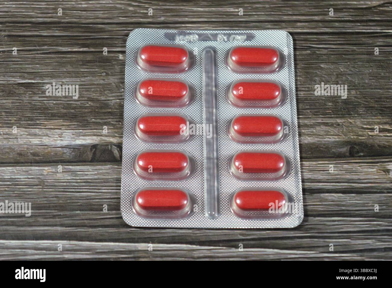 Comprimés de médicaments, comprimés rouges, traitement, remède, consommation de drogues, abus, concept de prescription, analgésiques et antibiotiques, analgésiques, prise d'un médicament Banque D'Images