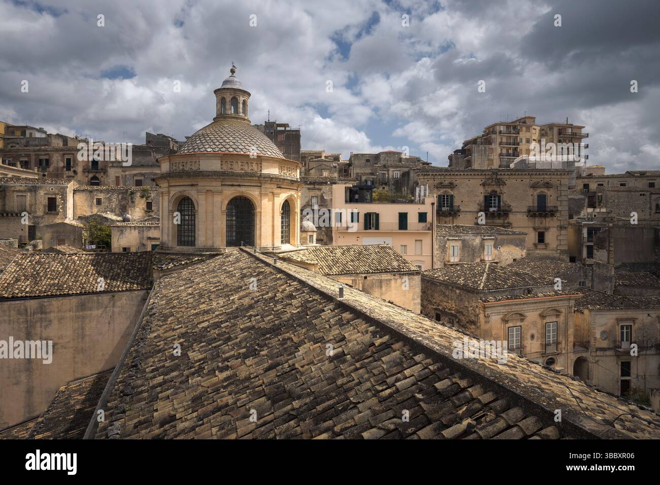 Les nuages passent au-dessus du magnifique Duomo Di San Giorgio, mettant en valeur l'architecture sicilienne parmi les charmants toits, Sicile, Italie Banque D'Images