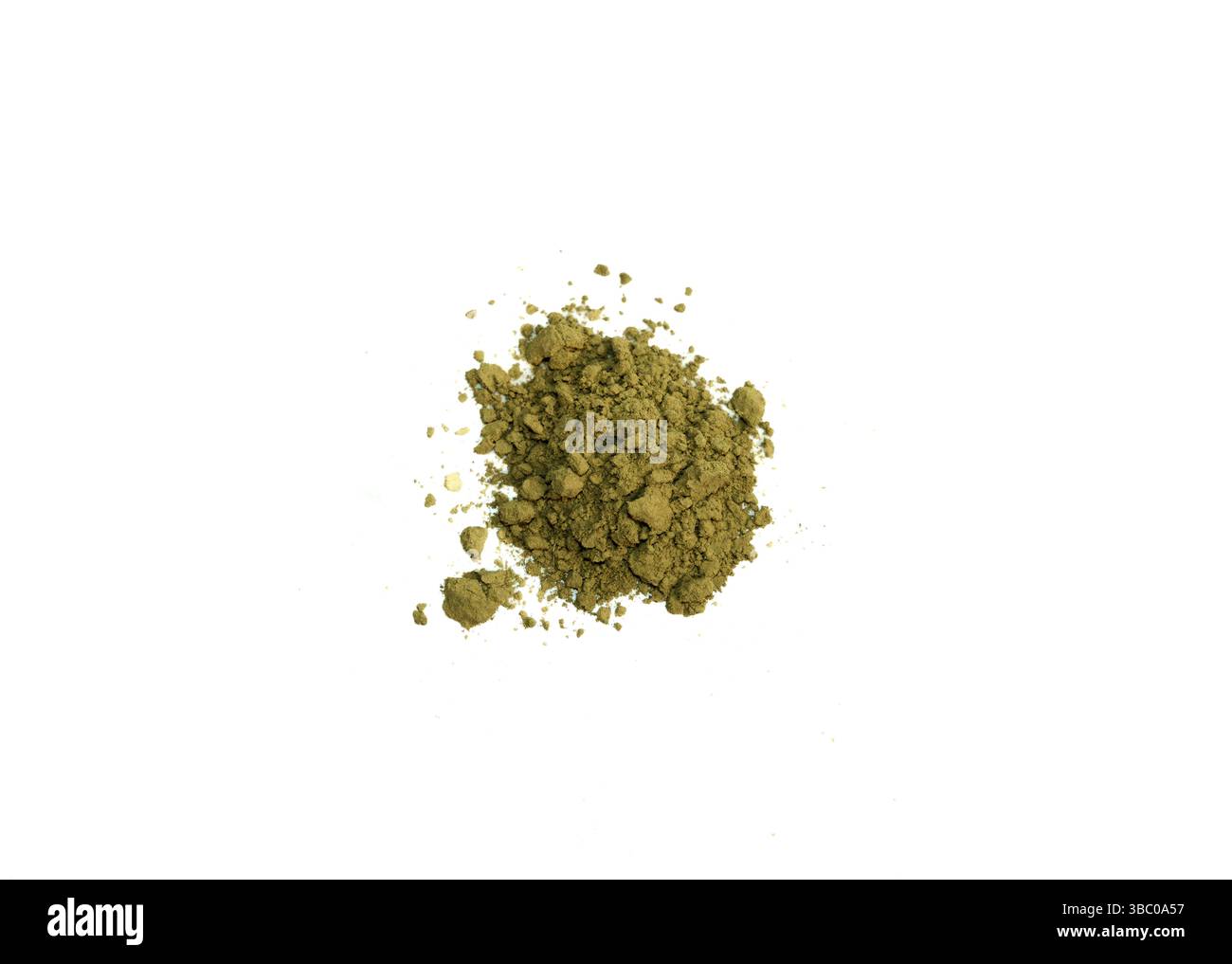 Un tas de poudre vert olive repose sur un fond blanc. De petites particules sont dispersées autour du amas principal. La poudre a une texture légèrement grossière Banque D'Images