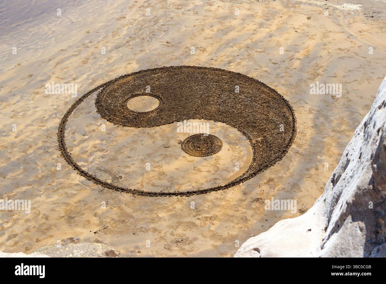 yin et Yang symbole dessiné grand dans le sable sur la plage à el medano tenerife espagne concept est originaire de la philosophie chinoise, opposés égaux Banque D'Images