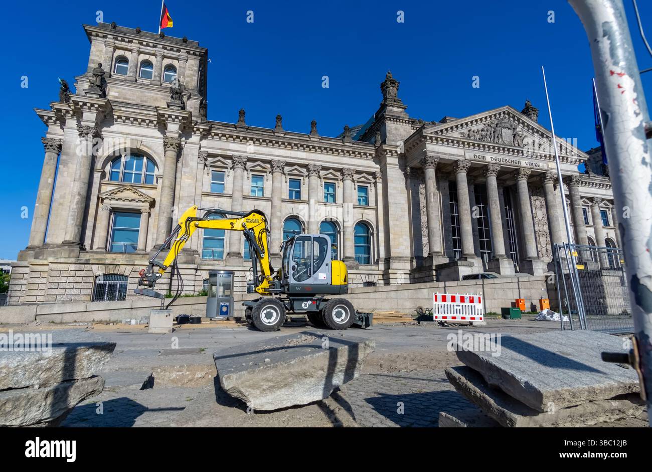 Le Reichstag allemand à Berlin, allemagne, avec une grande pelle jaune devant l'entrée pendant les travaux de construction du bâtiment historique. Banque D'Images