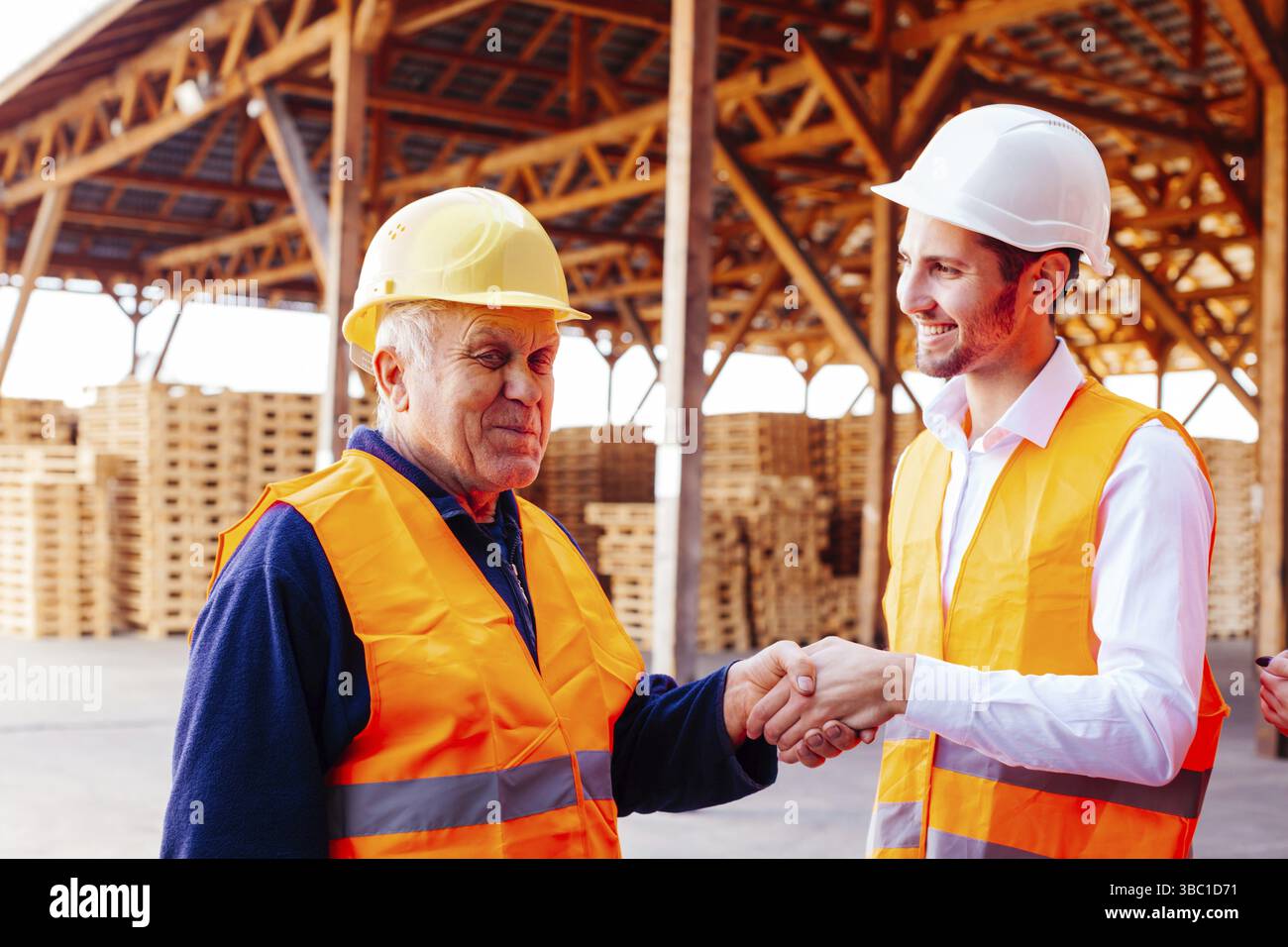 Portrait du jeune directeur de la société de construction remercie et se serrer la main avec un contremaître expérimenté confiant. Être reconnaissant à l'employé pendant de nombreuses années de g Banque D'Images