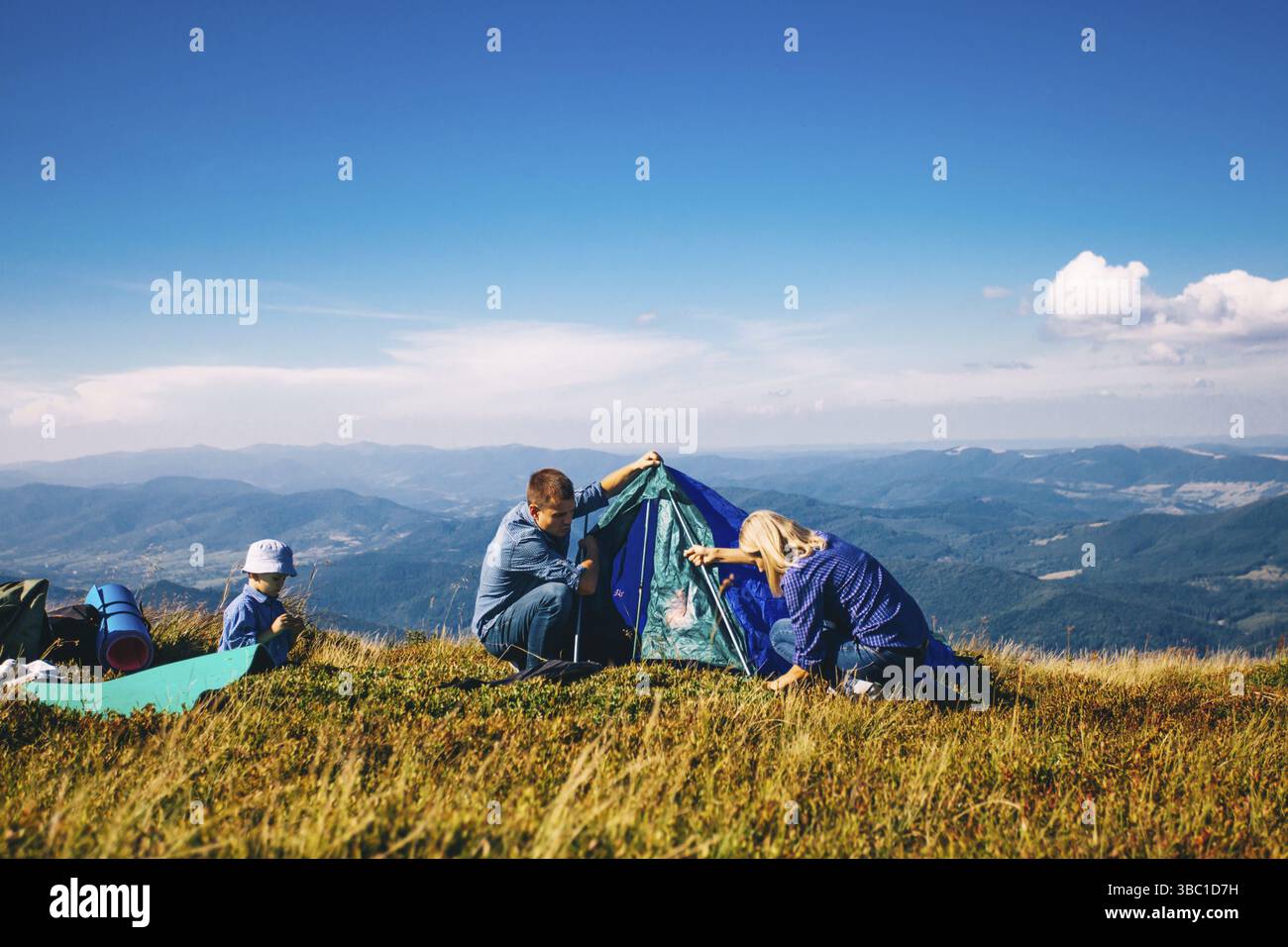 Mère et père faire tente dans les montagnes. Camp de vacances en famille Banque D'Images