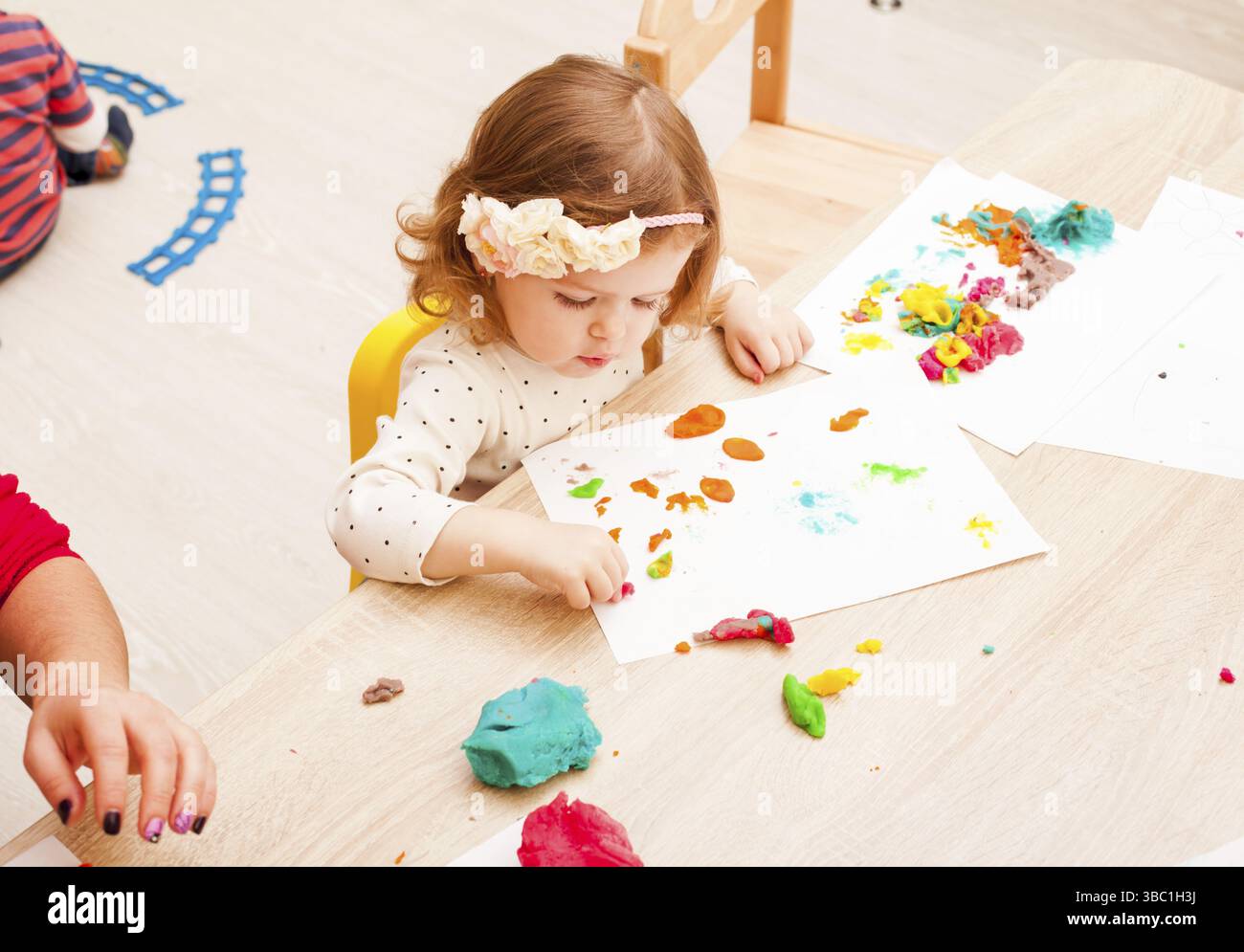 Les enfants jouent avec de l'argile à modeler sur la table Banque D'Images