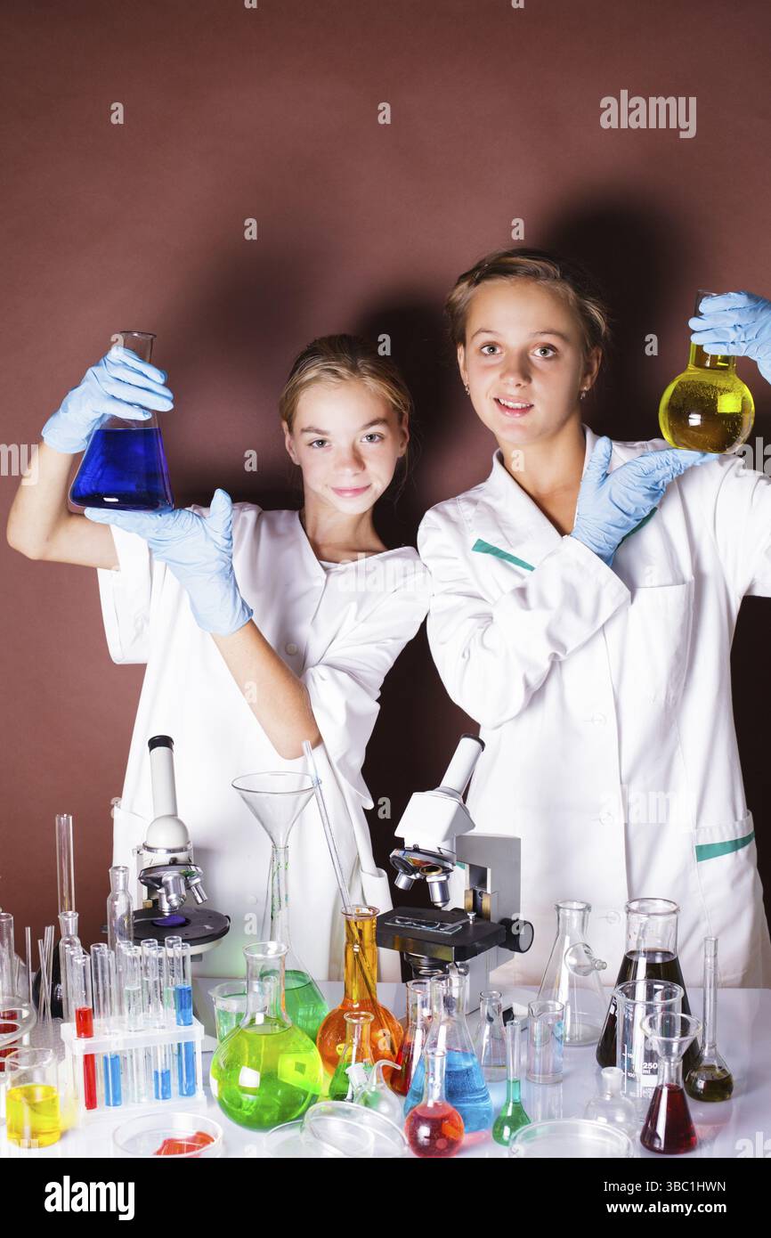 Deux élèves à la leçon de chimie sont debout près de tableau noir Banque D'Images