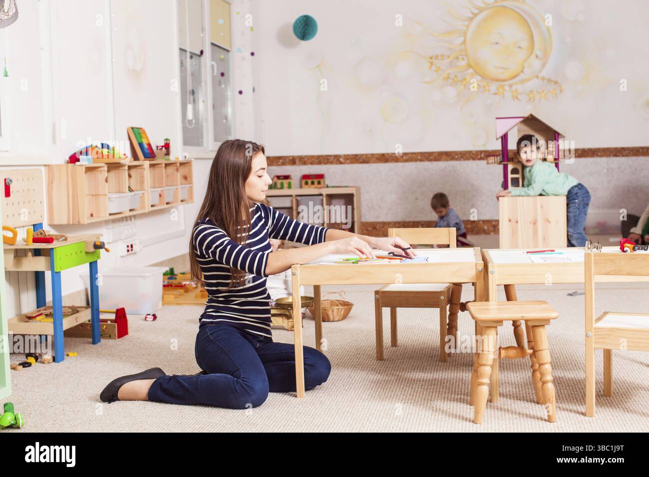 Belle enseignante au jardin d'enfants aimant son travail Banque D'Images