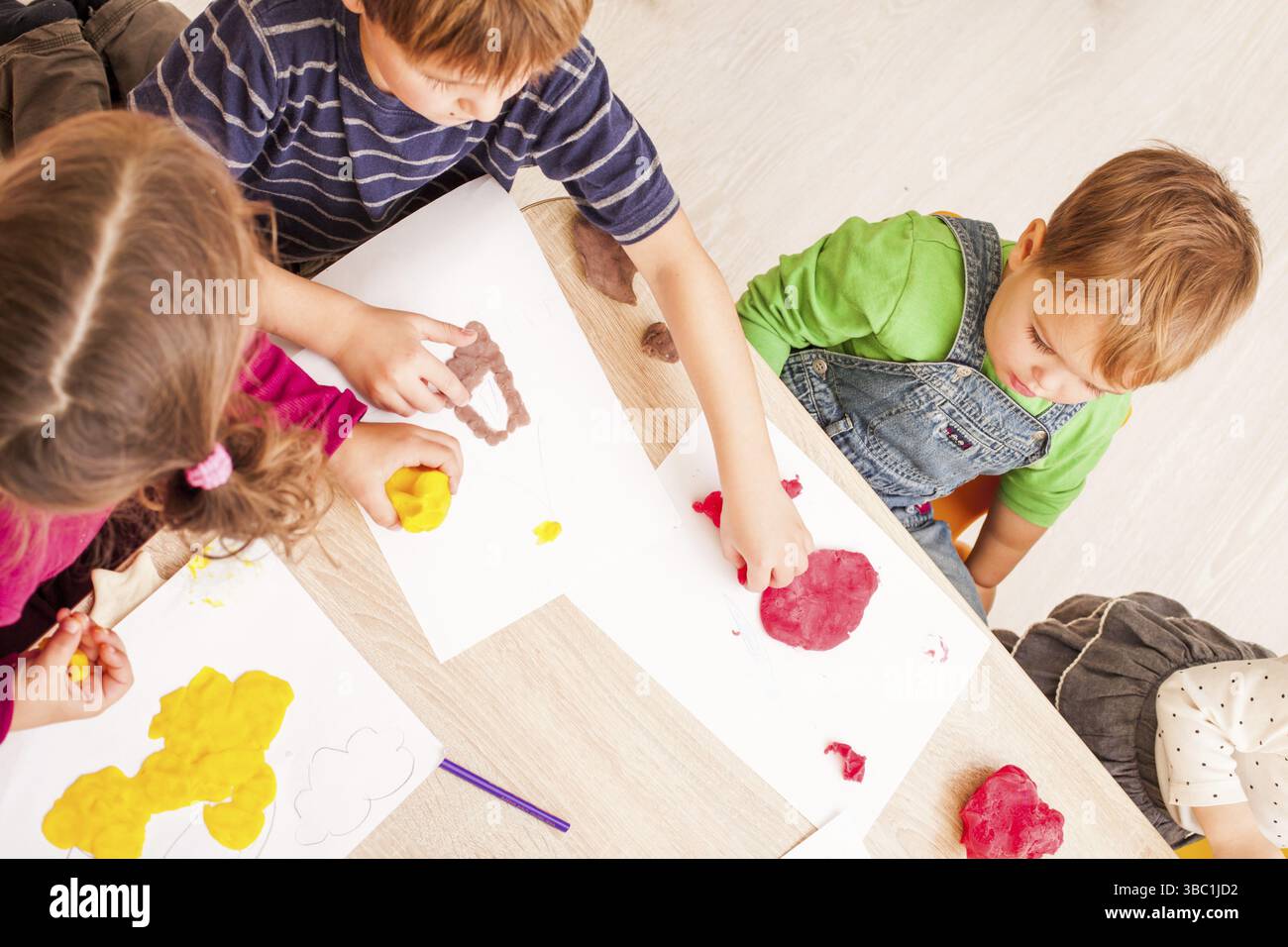 Les enfants jouent avec de l'argile à modeler sur la table Banque D'Images