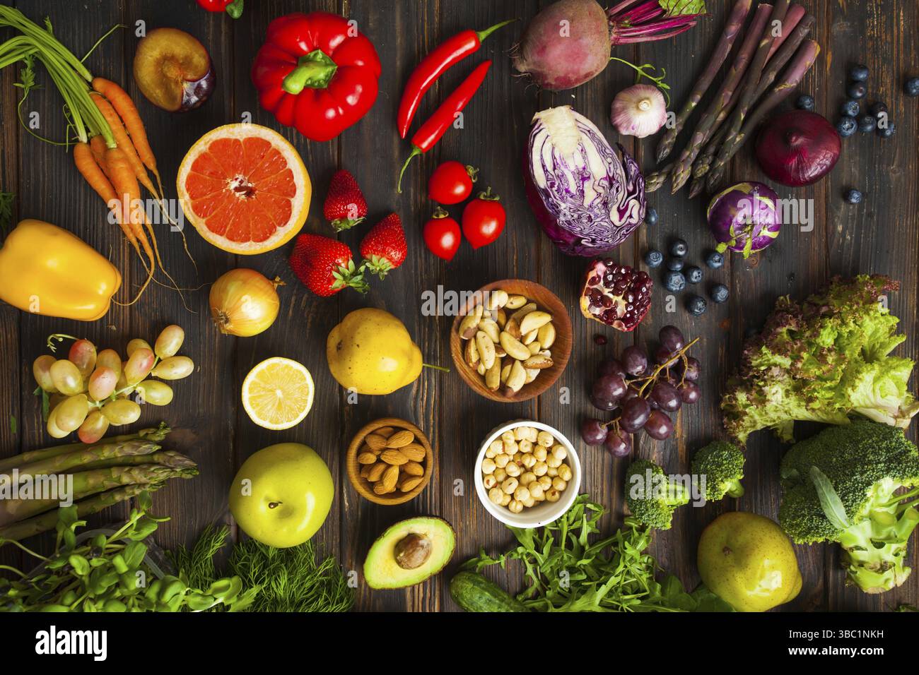 Vue de dessus de la table sombre avec divers produits frais. Légumes, fruits et noix pour une longue vie saine. Concept de nutrition anti-âge Banque D'Images