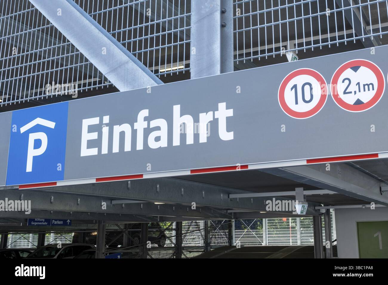 Panneau d'entrée du garage de stationnement indiquant la limite de vitesse et la limitation de hauteur, avec le mot allemand einfahrt signifiant entrée Banque D'Images