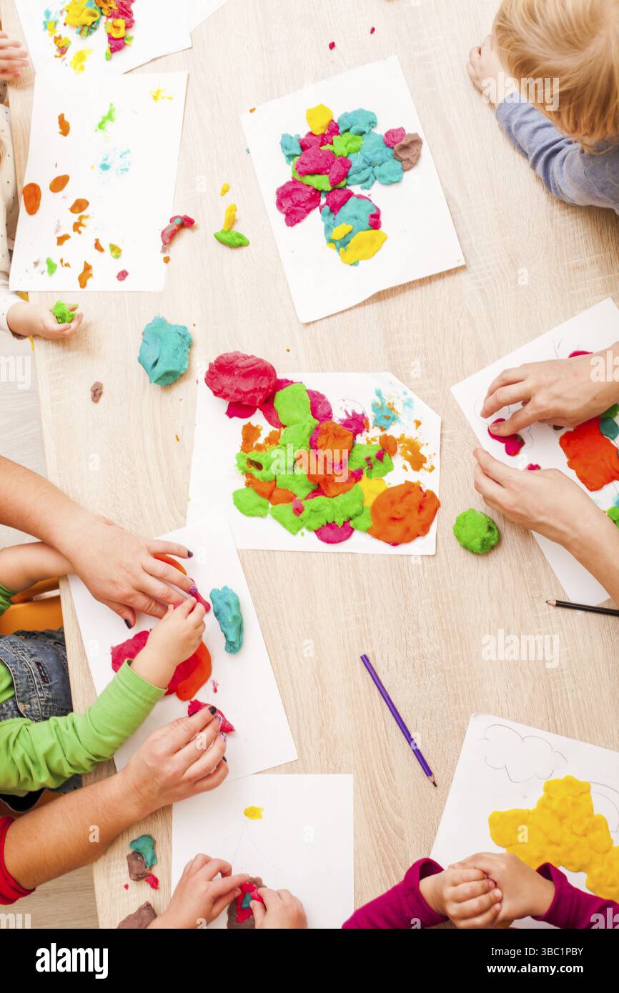 Les enfants jouent avec de l'argile à modeler sur la table Banque D'Images