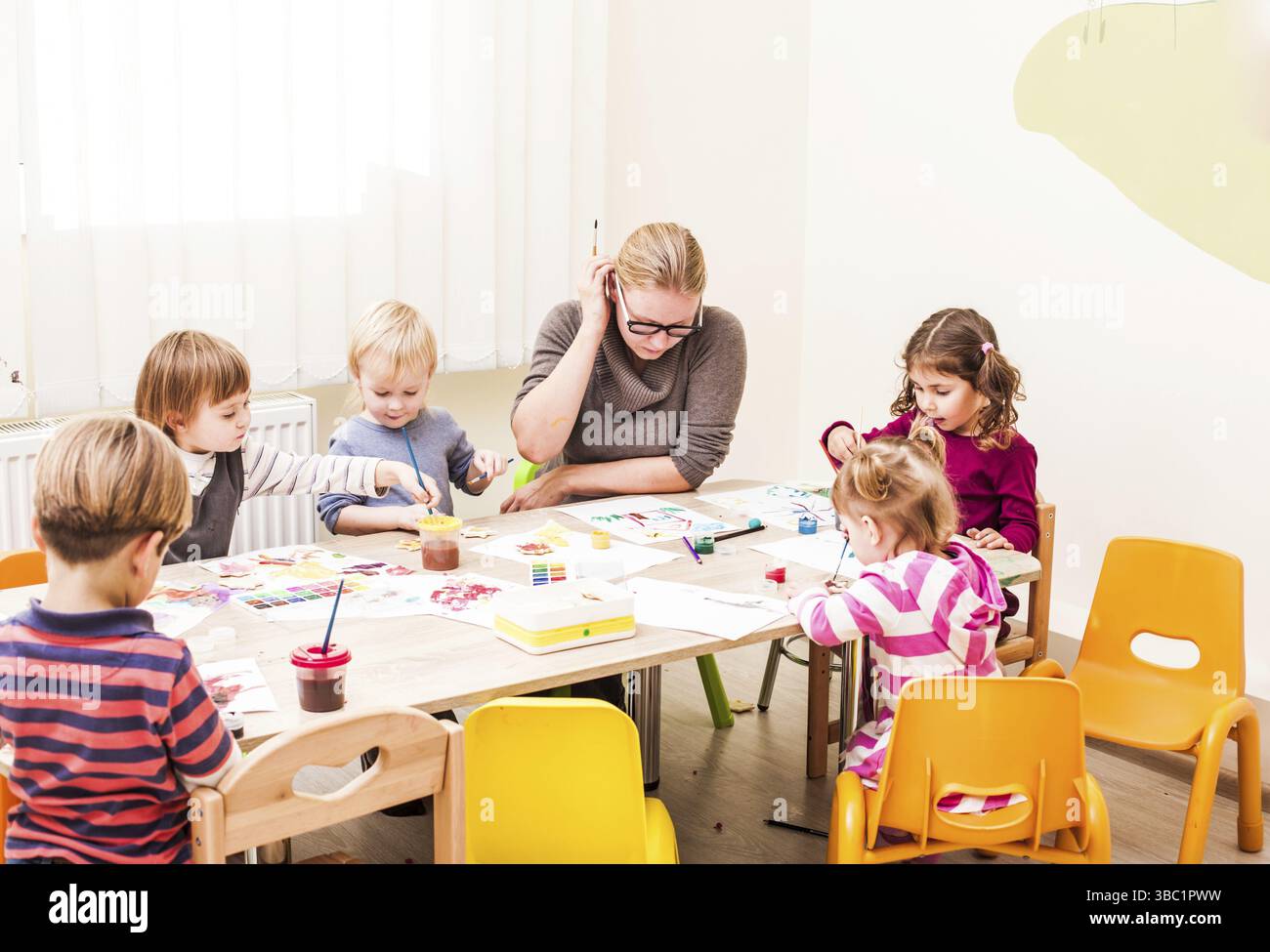 Les enfants sont la peinture avec un pinceau et d'aquarelles sur papier dans le jardin d'enfants Banque D'Images