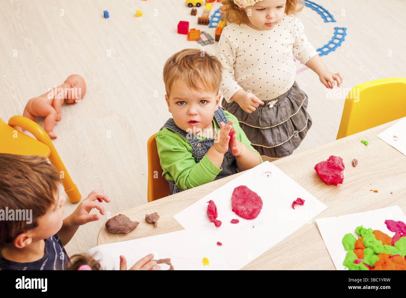 Les enfants jouent avec de l'argile à modeler sur la table Banque D'Images