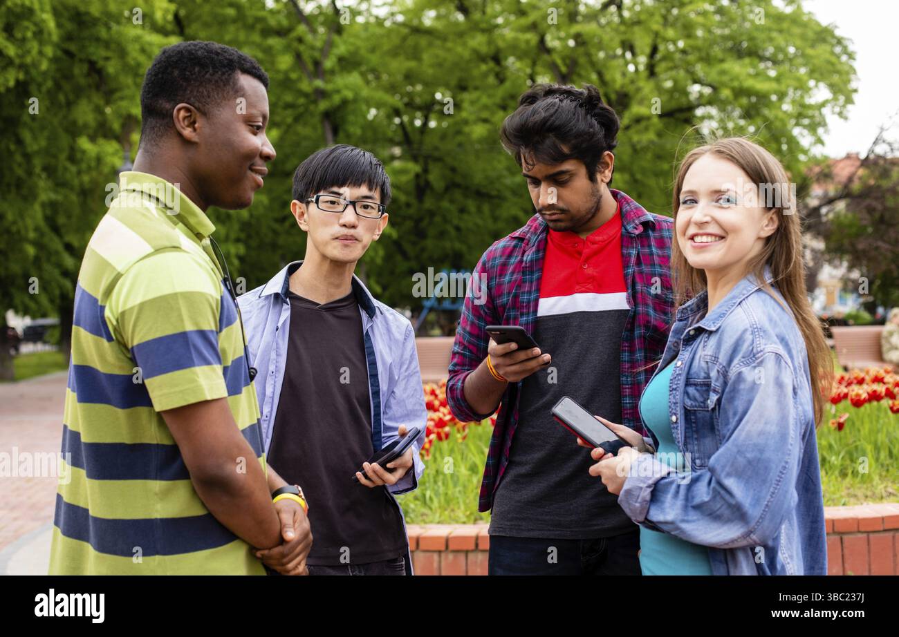 Un groupe d'étudiants divers communique facilement après des conférences universitaires. Établir des liens étroits entre les jeunes de différentes races et nationalités Banque D'Images