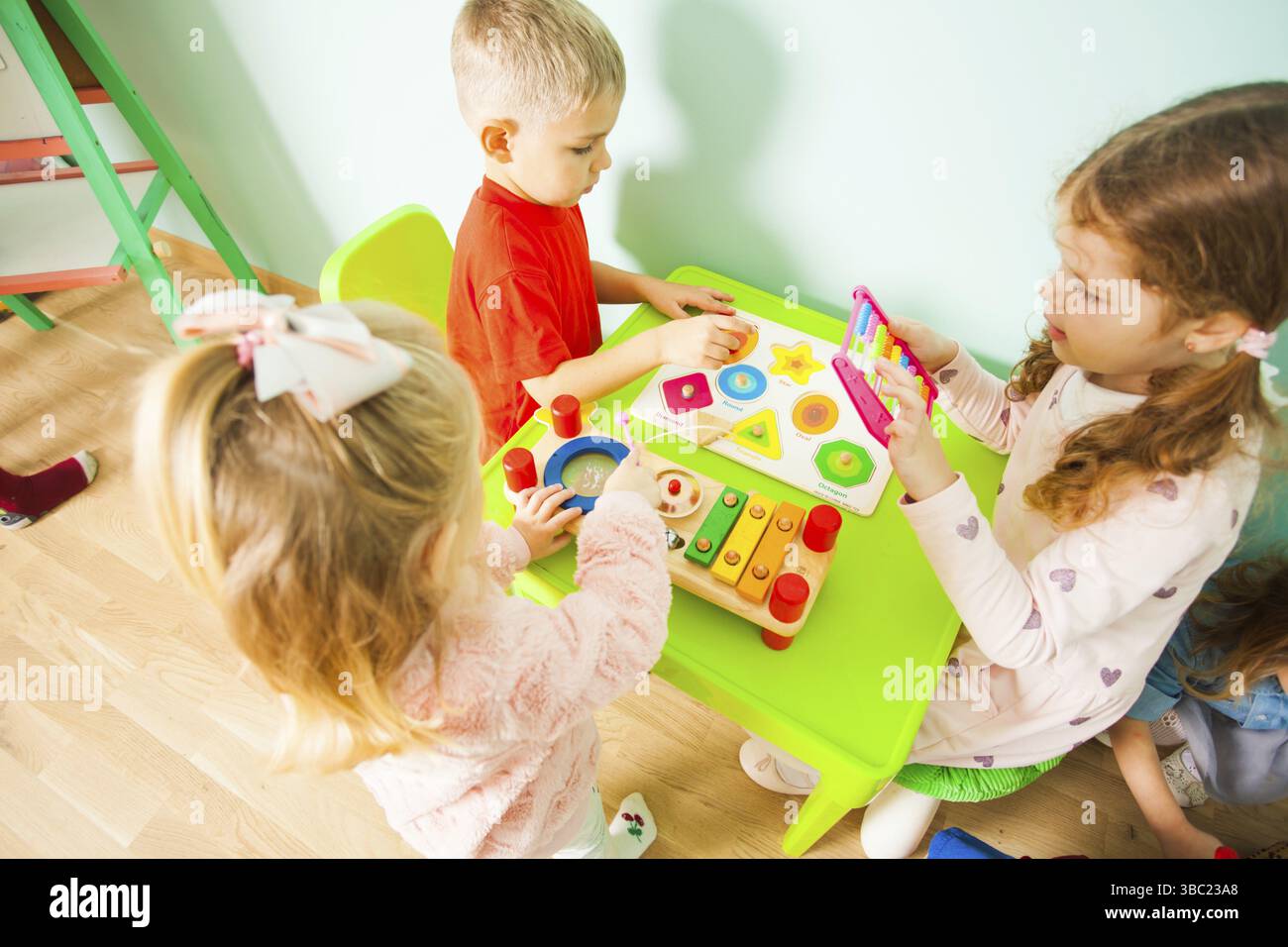 Enfants jouant avec de la musique et des jouets mathématiques. Enfant garçon et filles assis à la table dans la salle de jeux Banque D'Images