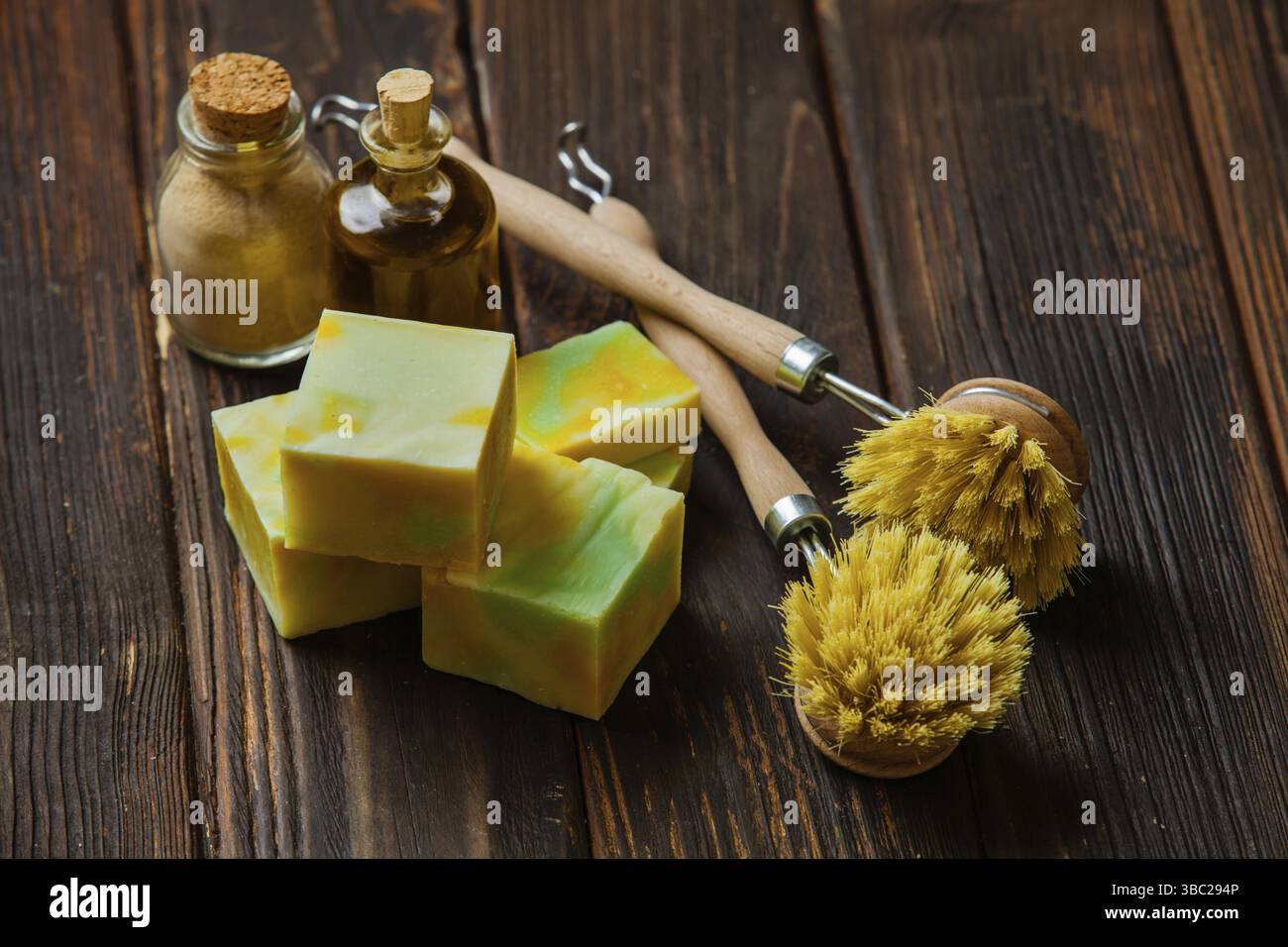 Outils de nettoyage compostables pour la cuisine. Brosse à vaisselle en bois, savon maison bio et poudre sur la table en bois Banque D'Images