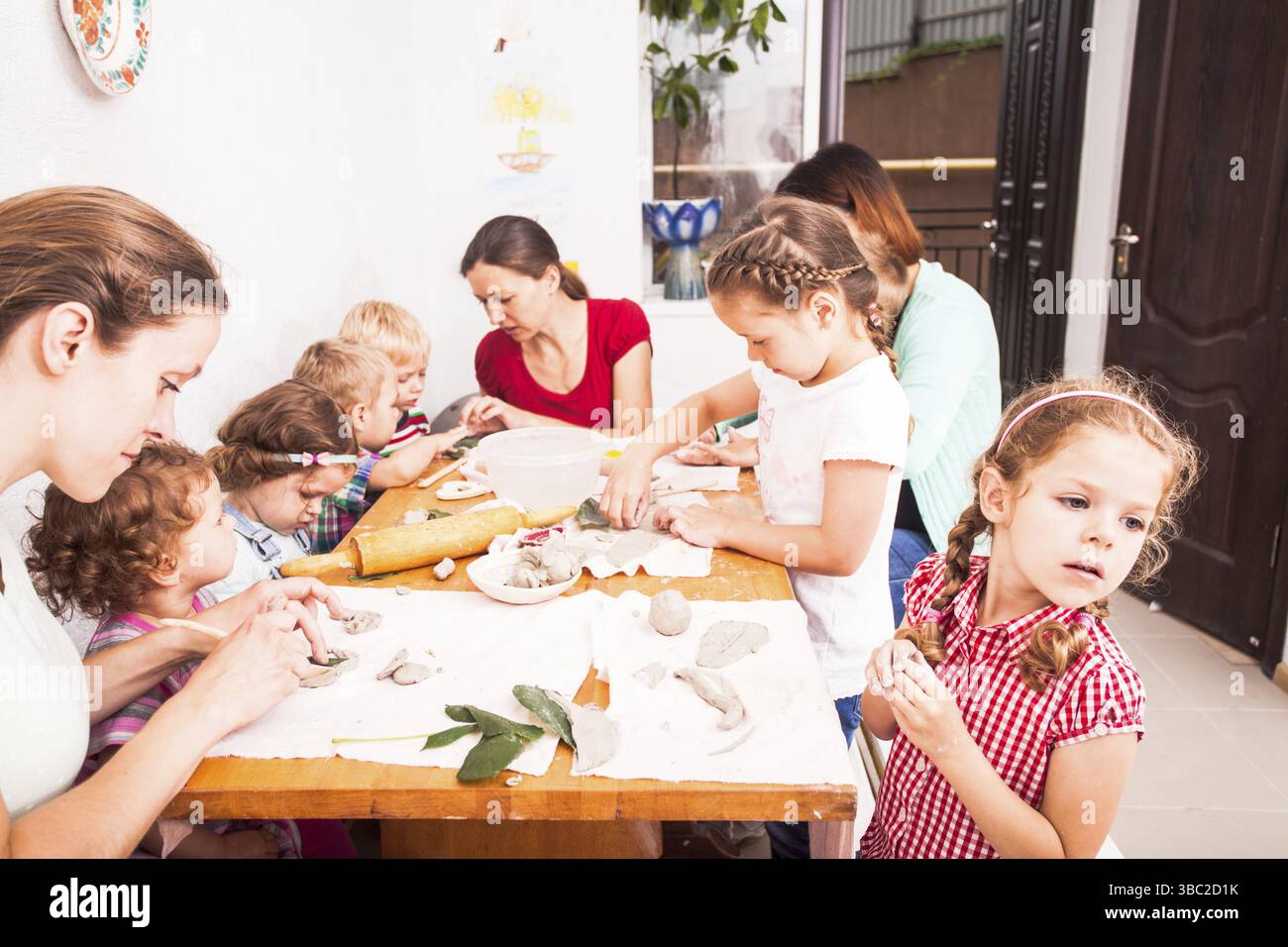 Les enfants avec des mères sont sculpter avec de l'argile. La thérapie d'argile et le développement de fines compétences de moteur. Journée en famille pour passer du bon temps ensemble Banque D'Images