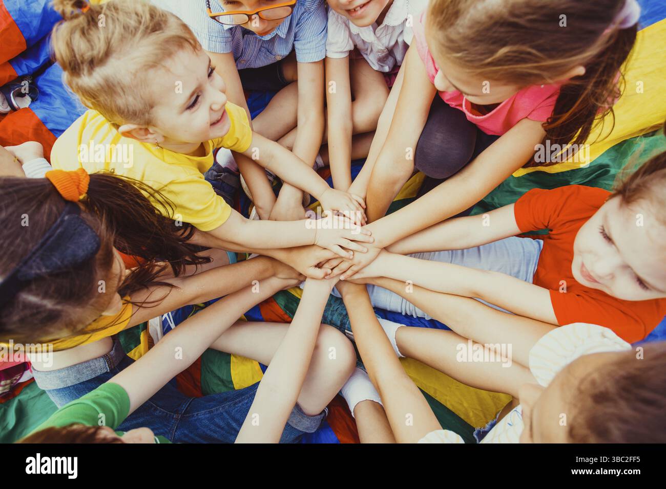 Groupe d'enfants mettant leurs mains ensemble sur un fond coloré.Concept de diversité Banque D'Images